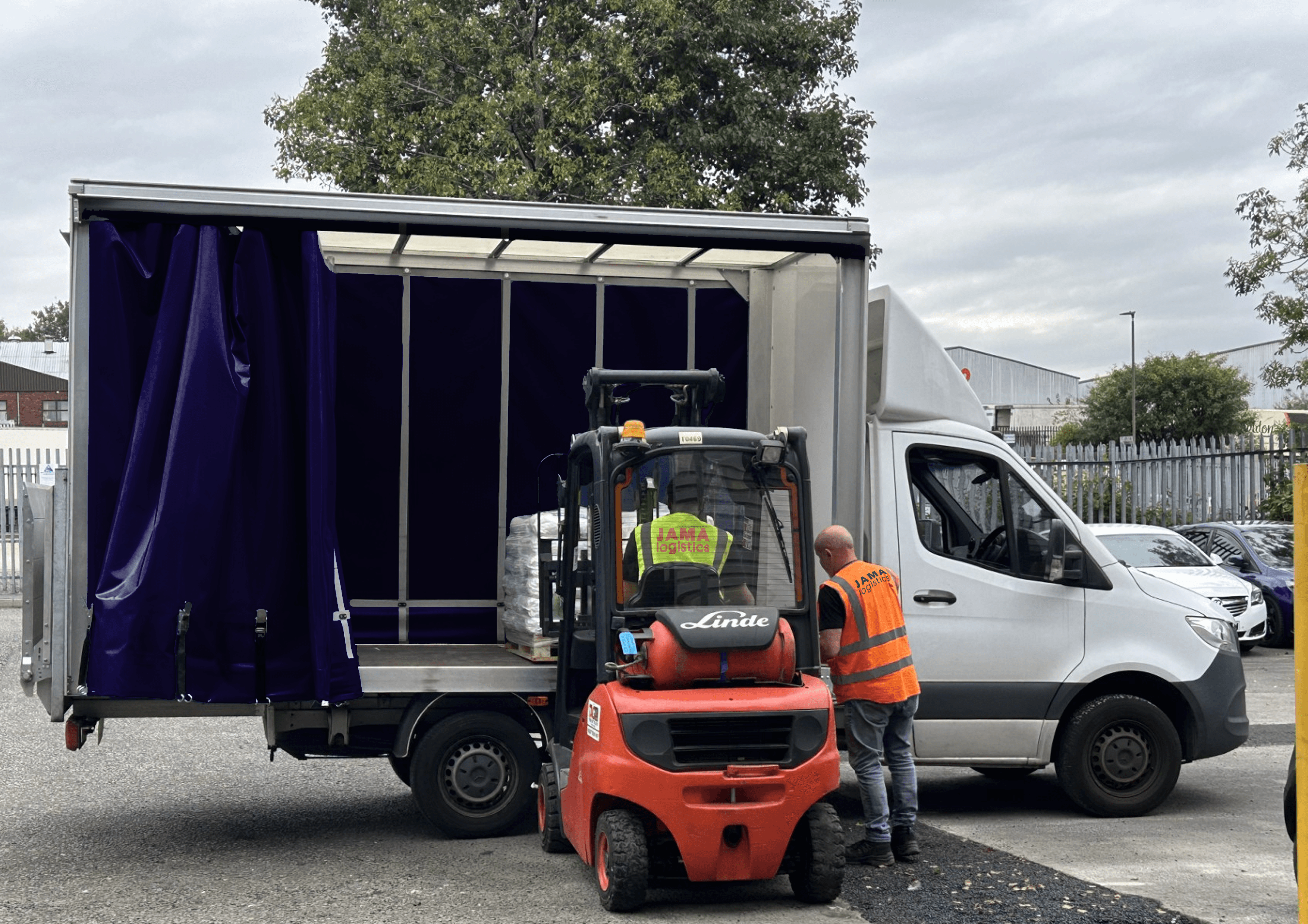 image of a forklift loading a luton with a pallet and two men wearing high vis
