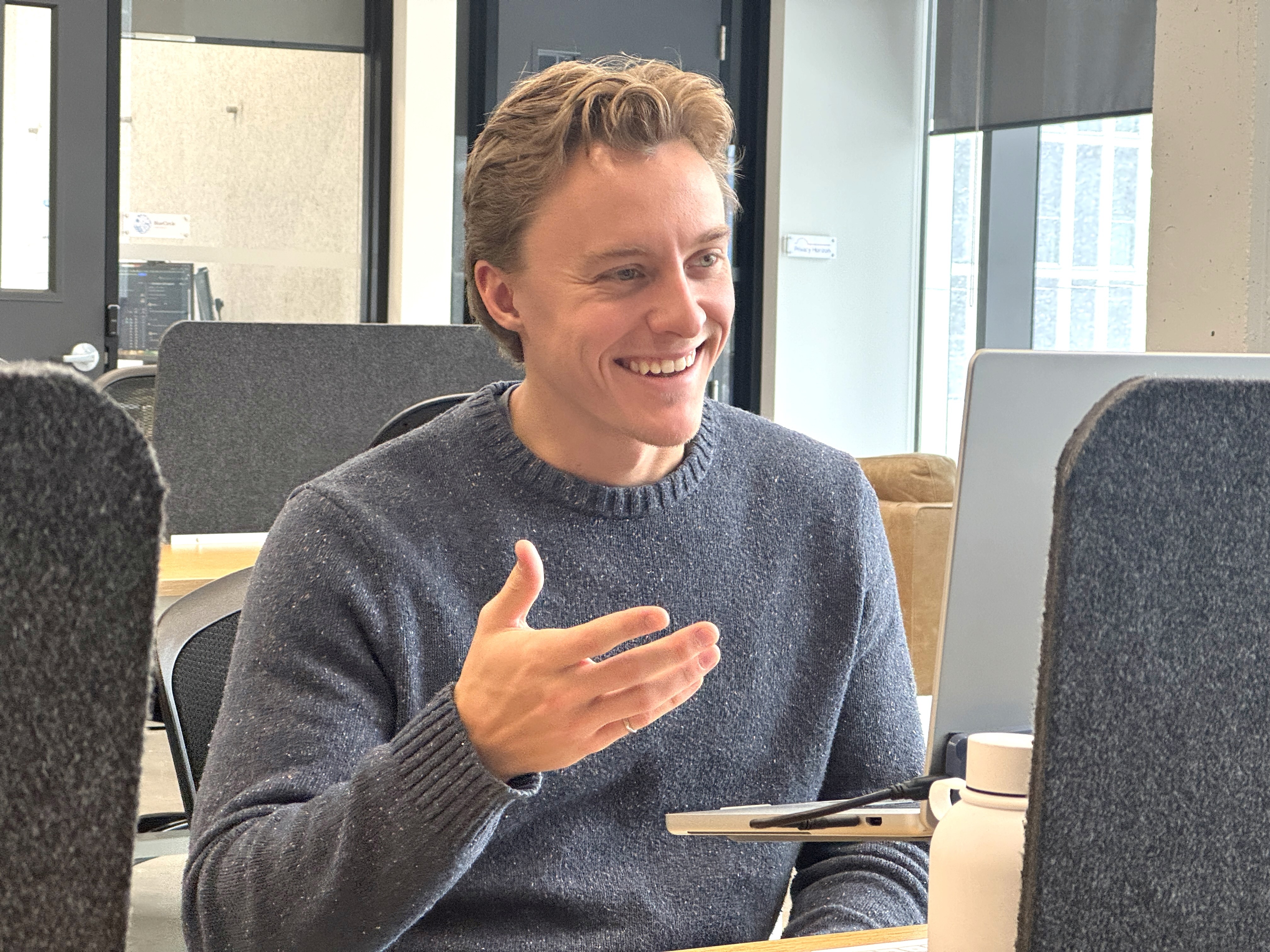 two men sitting at a table with papers and a pen