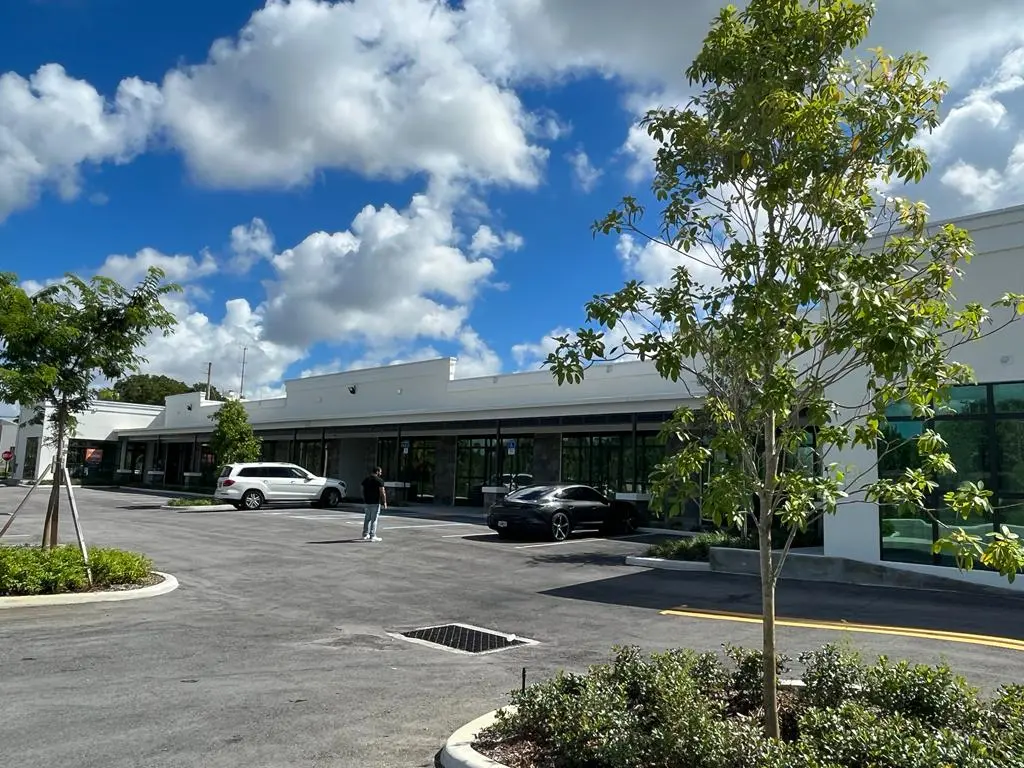 Completed retail strip center with parking lot and modern white facade, SW 27th Street Fort Lauderdale