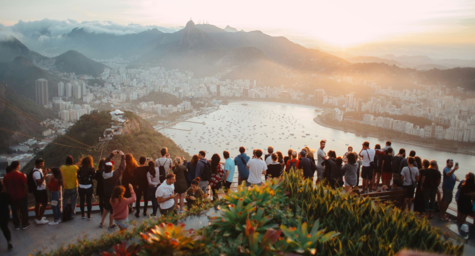 paisagem da praia de copacabana observada de cima de um morro com turistas apreciando a vista