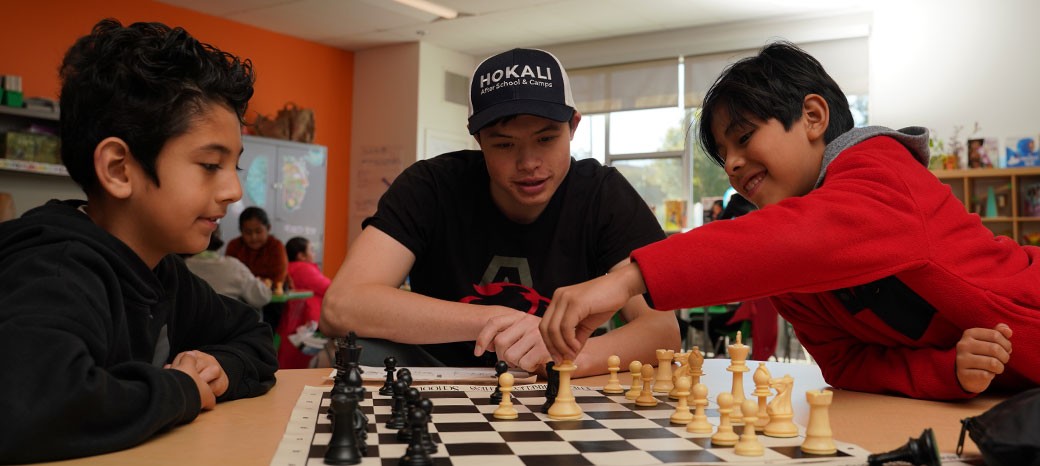 Students learning strategic thinking skills in structured after school chess program
