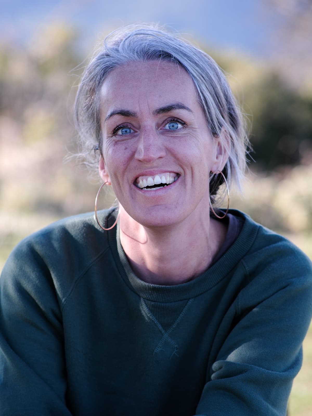 Portretfoto van Laura den Boeft, lachend in een buitenomgeving.