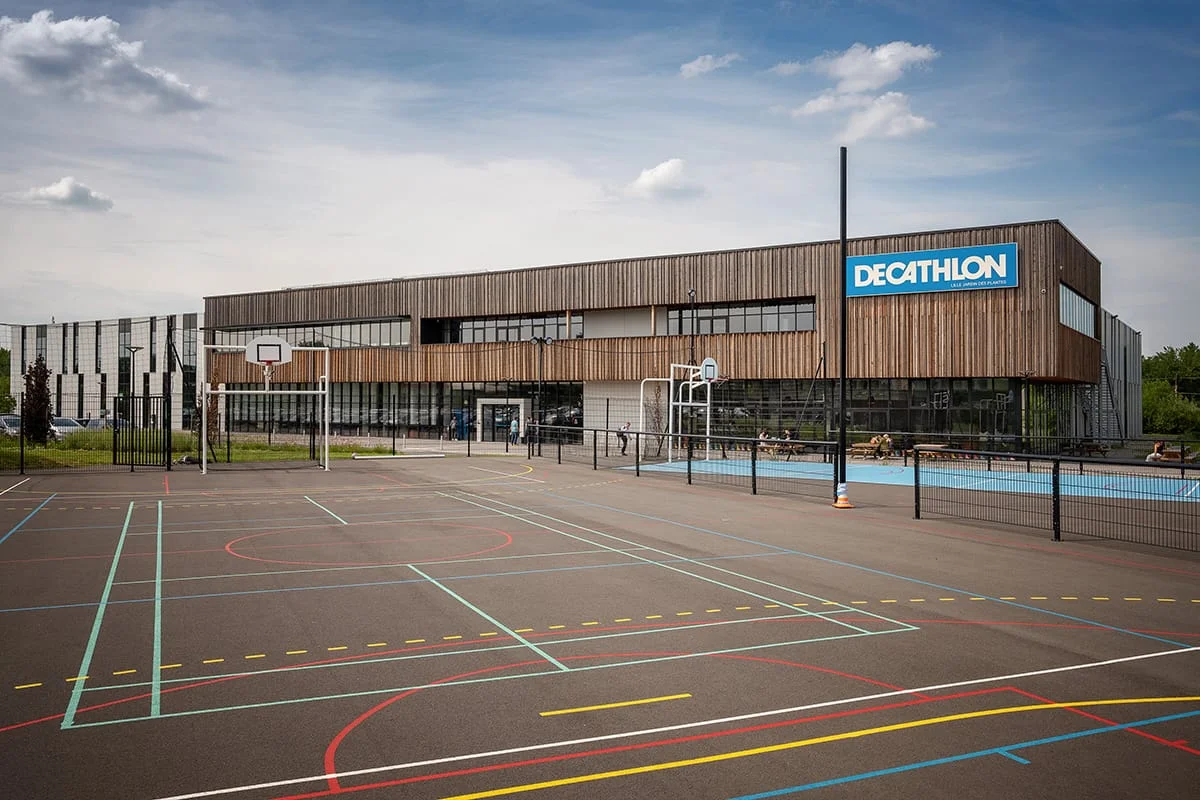 Bâtiment sportif Decathlon avec terrain multisport extérieur – photo architecture commerciale Lille Hauts de France 2025