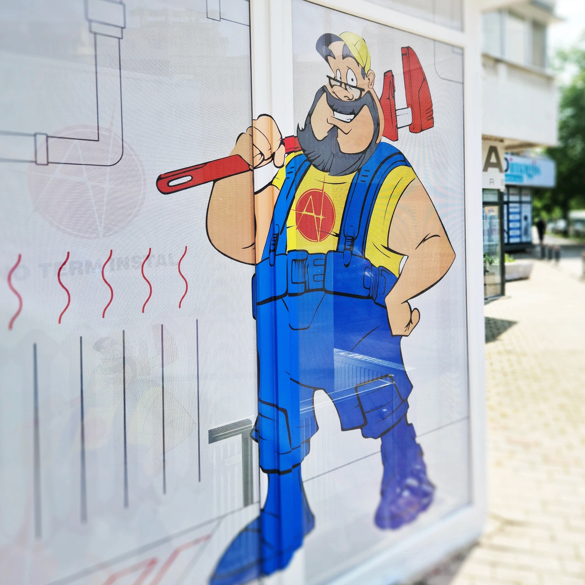 Mascotă instalator colantată pe geamul magazinului Ano Term Instal