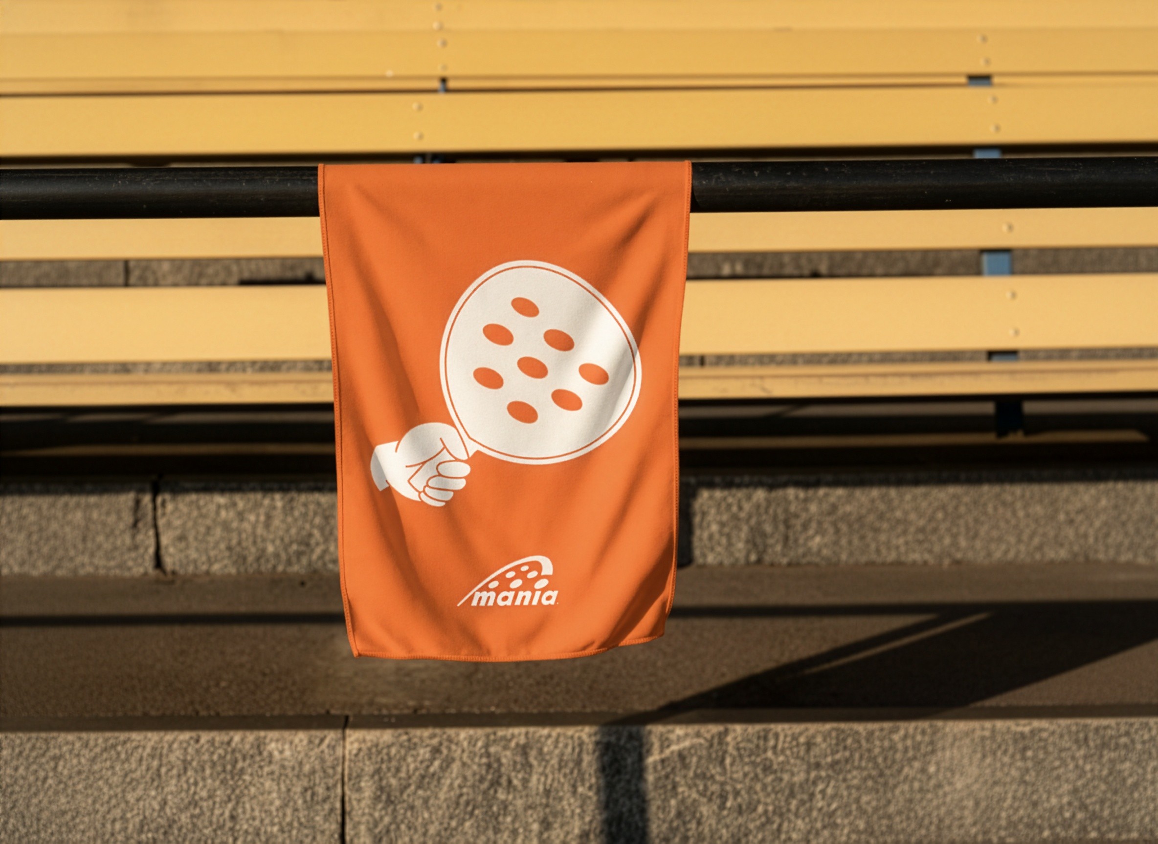 Coral colour towel with a padel racket illustration on it. Branded merchendise. 