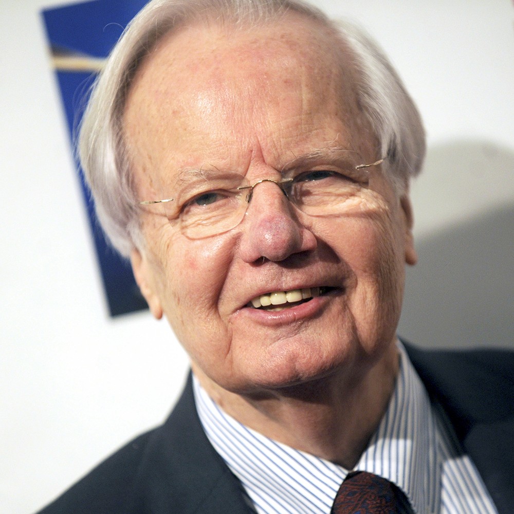 Portrait of journalist Bill Moyers, a smiling white-haired man with eyeglasses and a jacket and tie