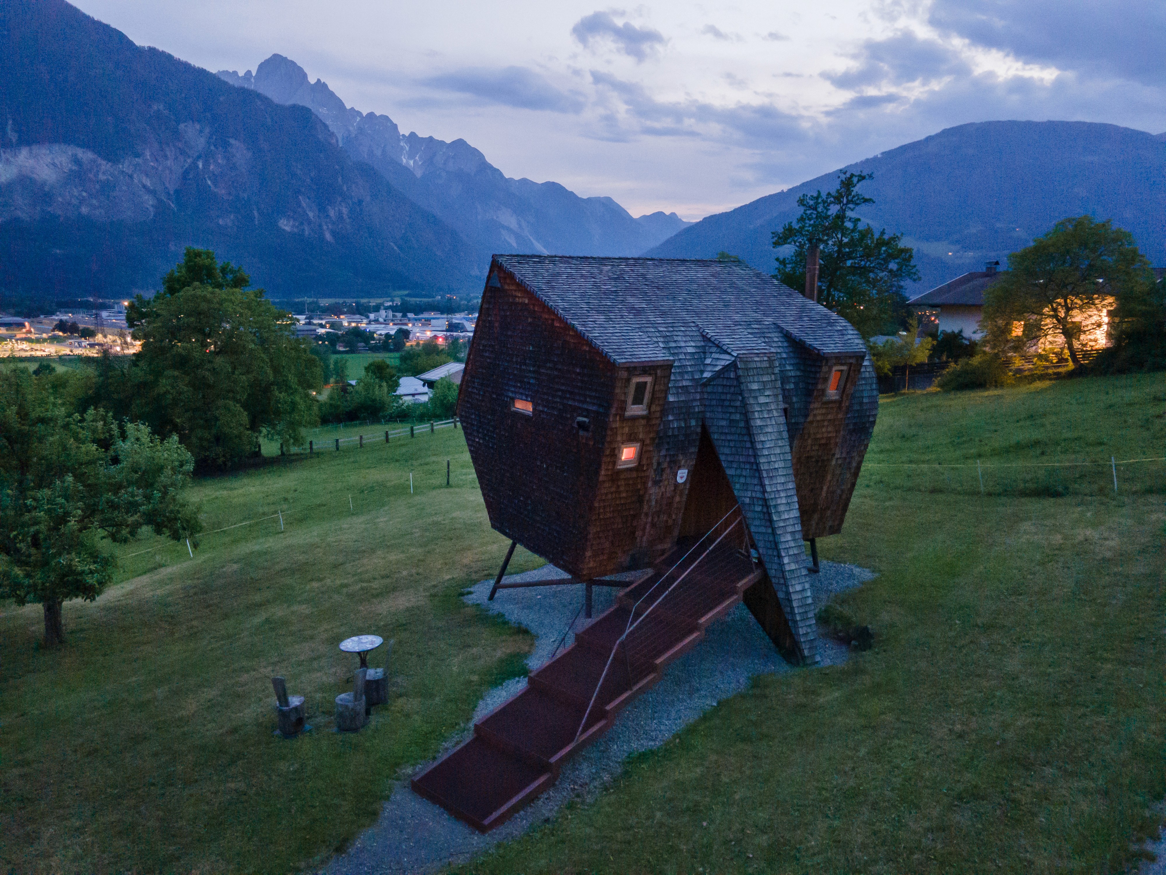 Ufogel’s sculptural wooden cabin in East Tyrol at dusk overlooking the Lienz valley and surrounding Alps