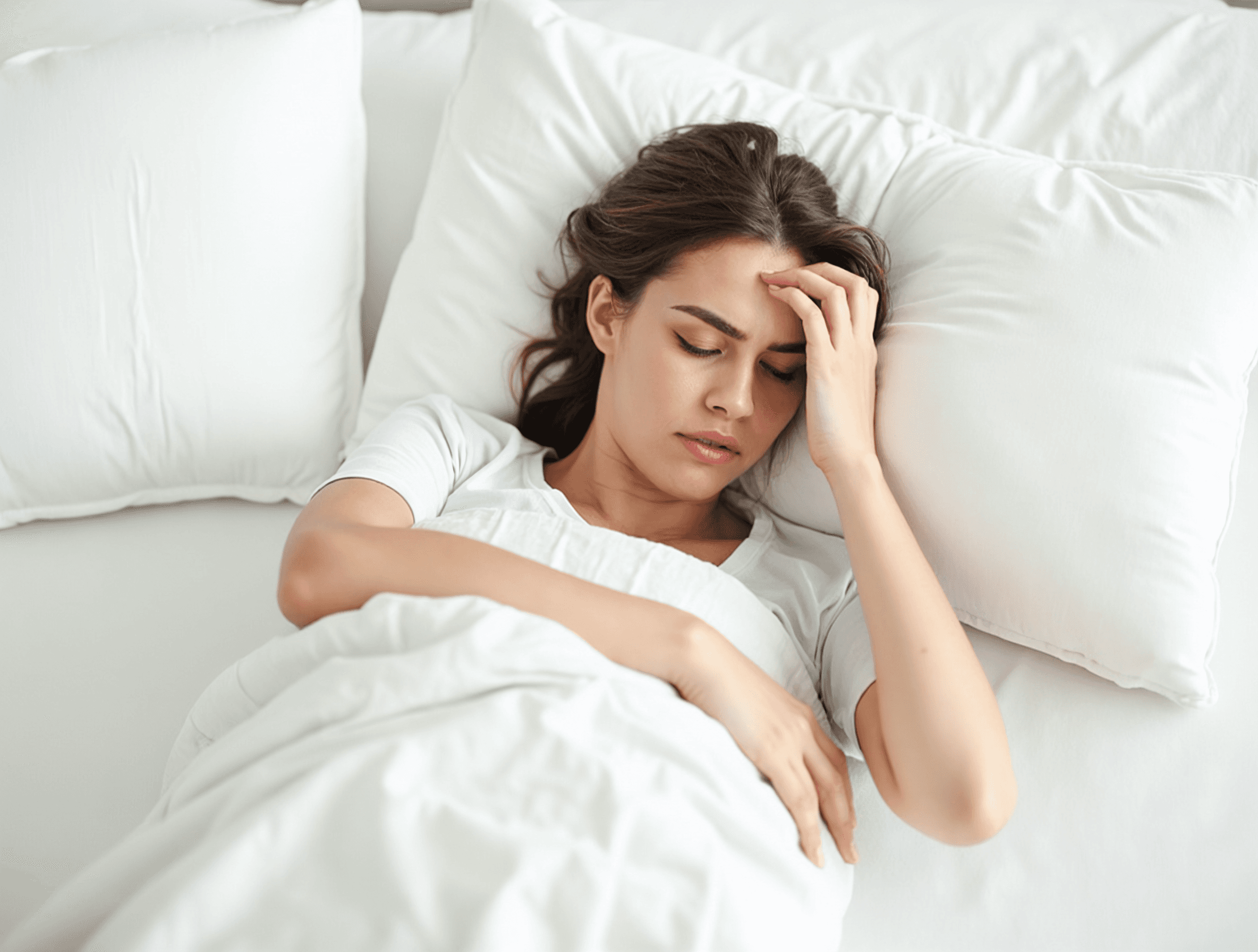 A woman experiencing fatigue sitting on a couch