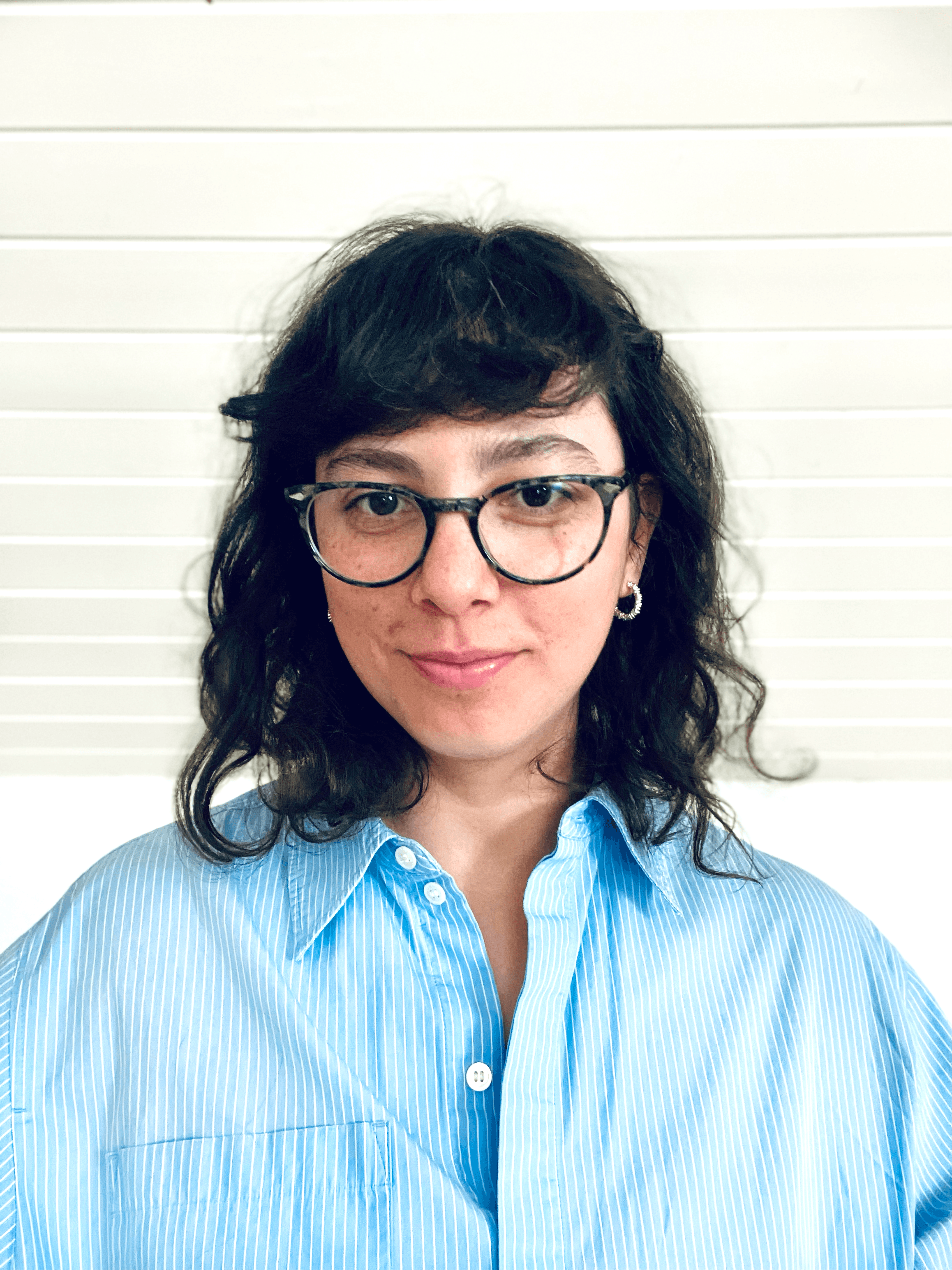 A thoughtful young person with dark hair gazes to the side, captured in soft black and white lighting.