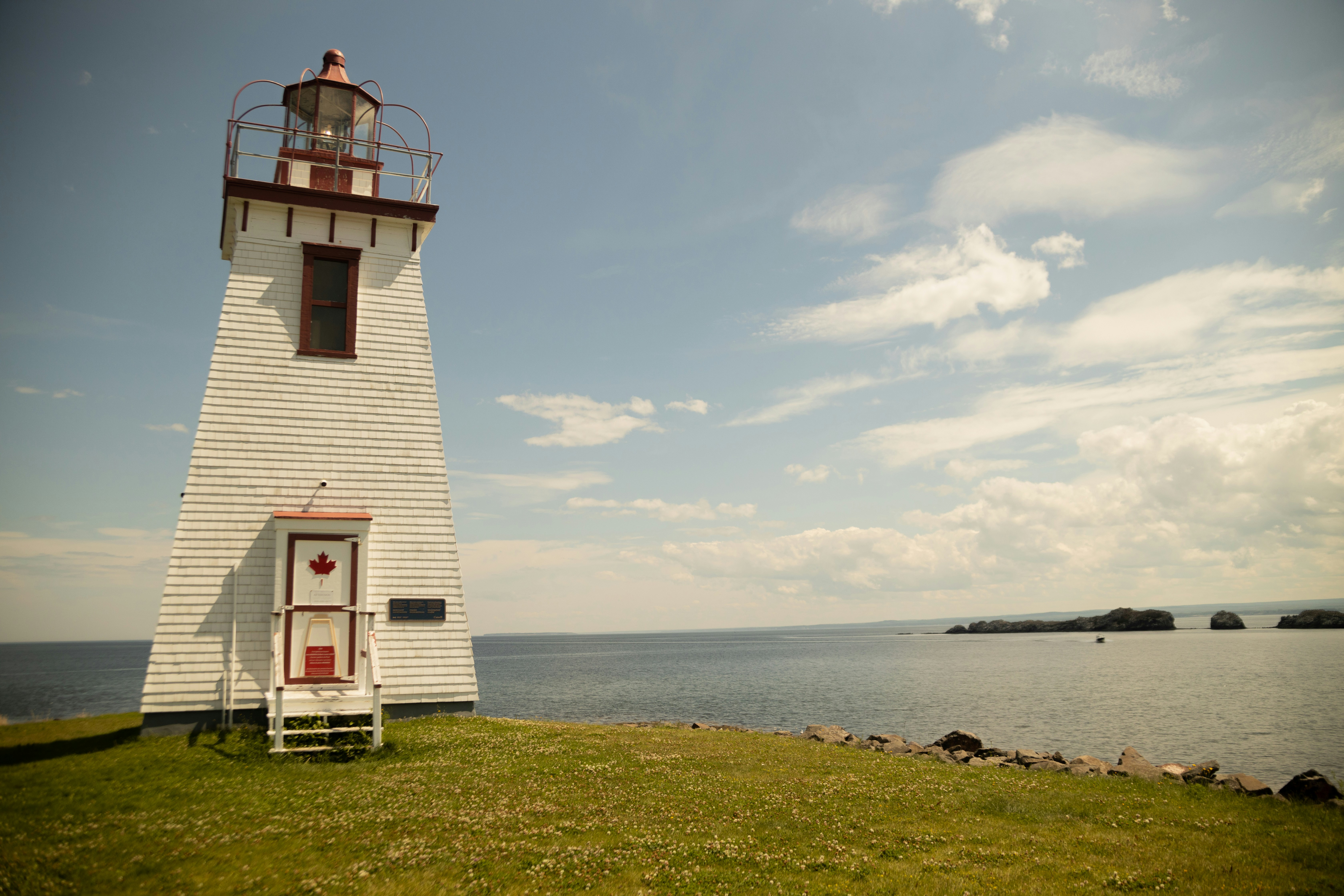 a light house sitting on top of a lush green field