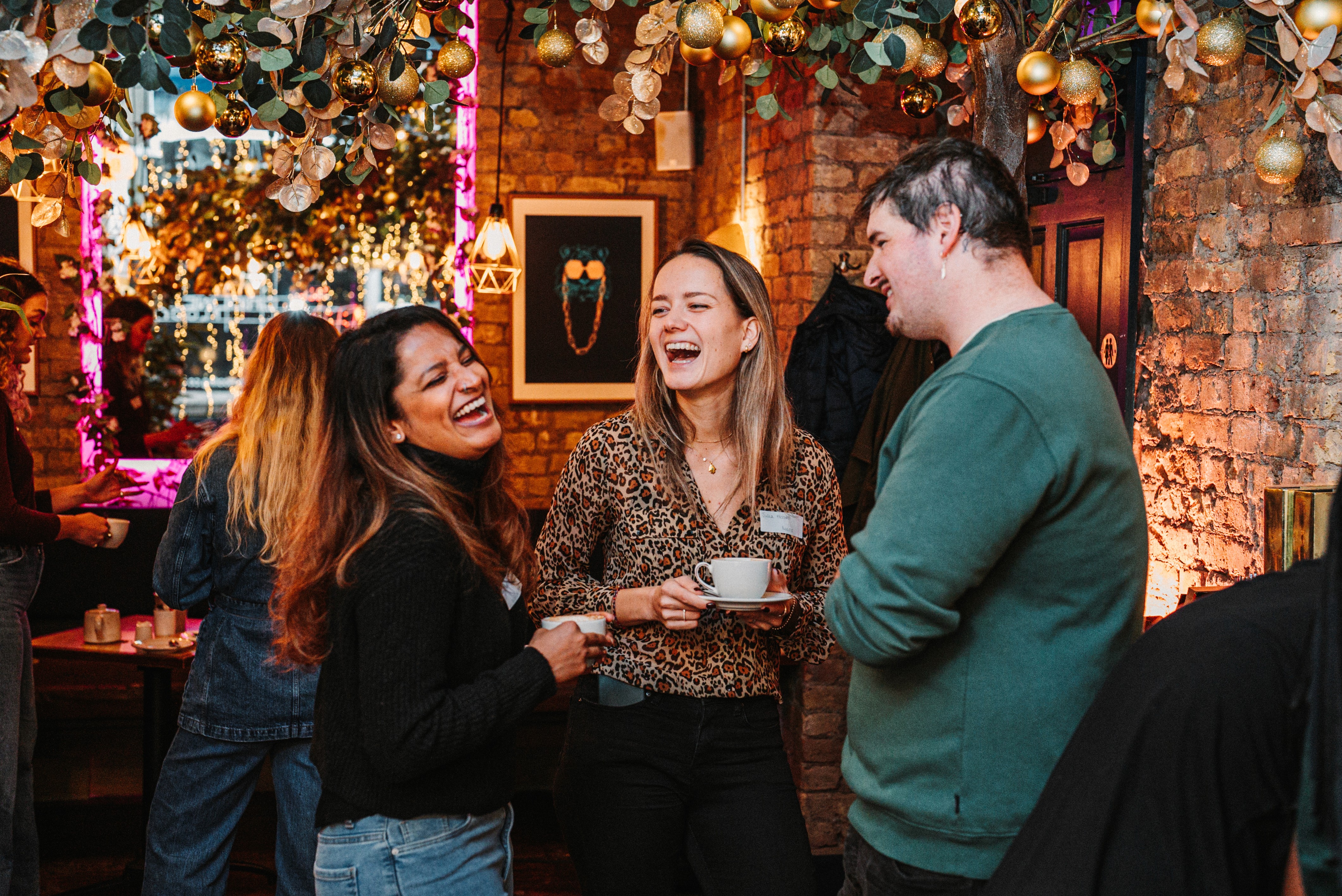 A PinPoint Media event where three people are conversing together in a nice moodlit room.