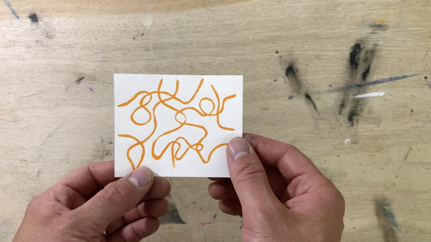 Détail macro d'une carte de visite en linogravure, tracé orange, gravée et imprimée à la main