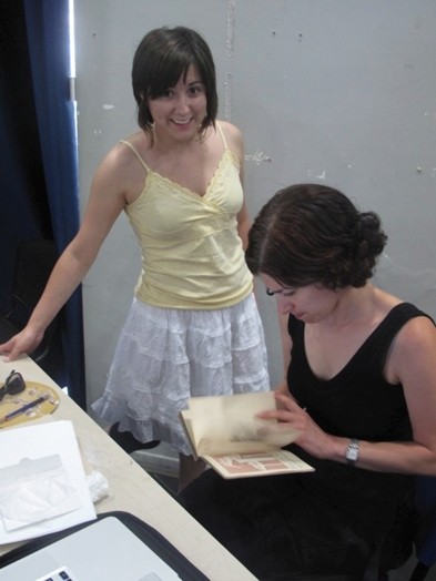 A photo of two girls checking notes.