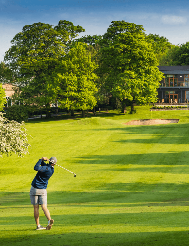 <img src="man-playing-golf.png" alt="A man playing golf on a lush green course, surrounded by trees and scenic landscapes." />
