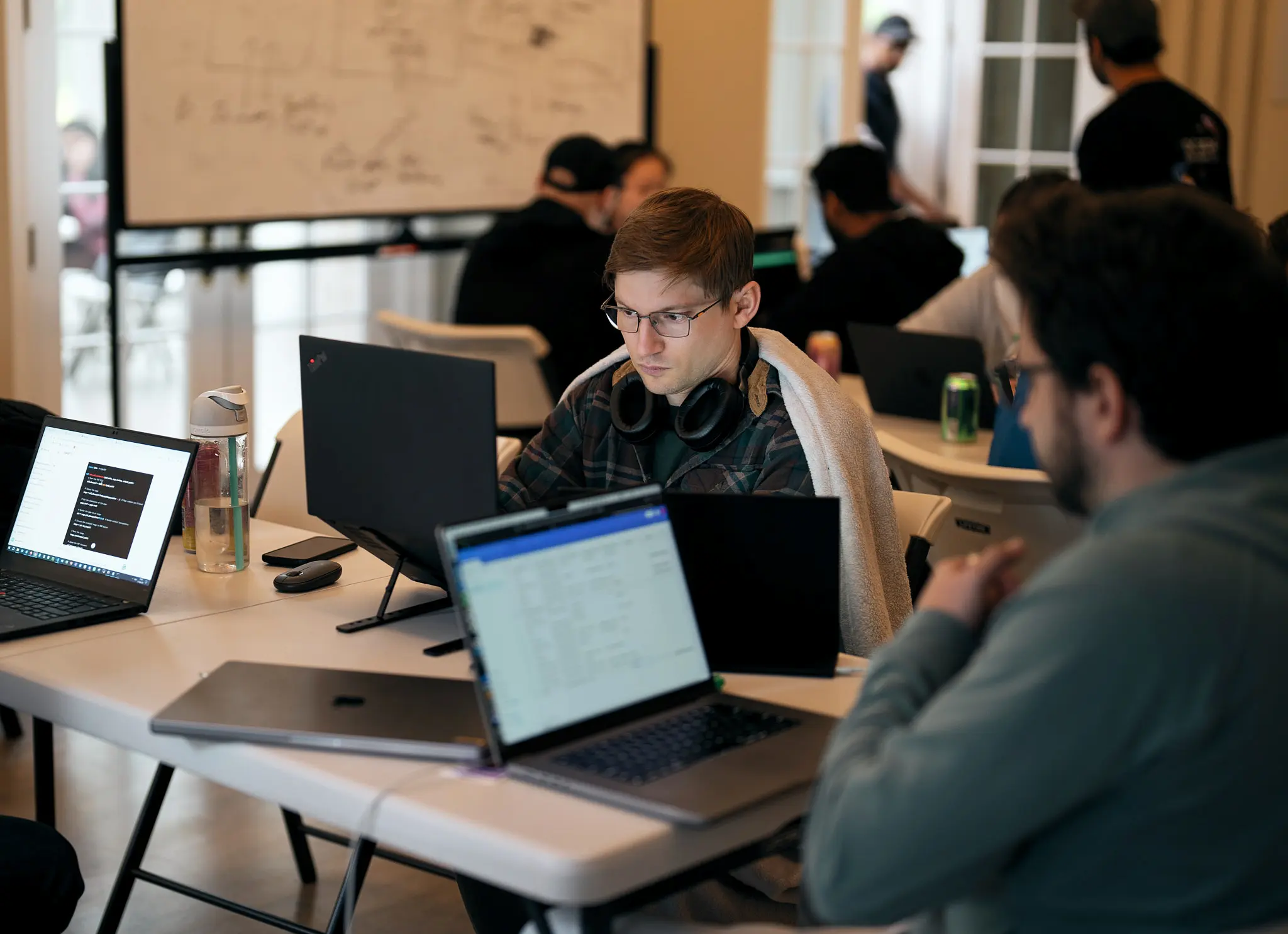 Focused engineer codes at a laptop during MadHats AI Wonderland Hackathon at AGI House — hackathon participant, AI project build, in-the-moment documentary storytelling, Sixtynice tech event photography.