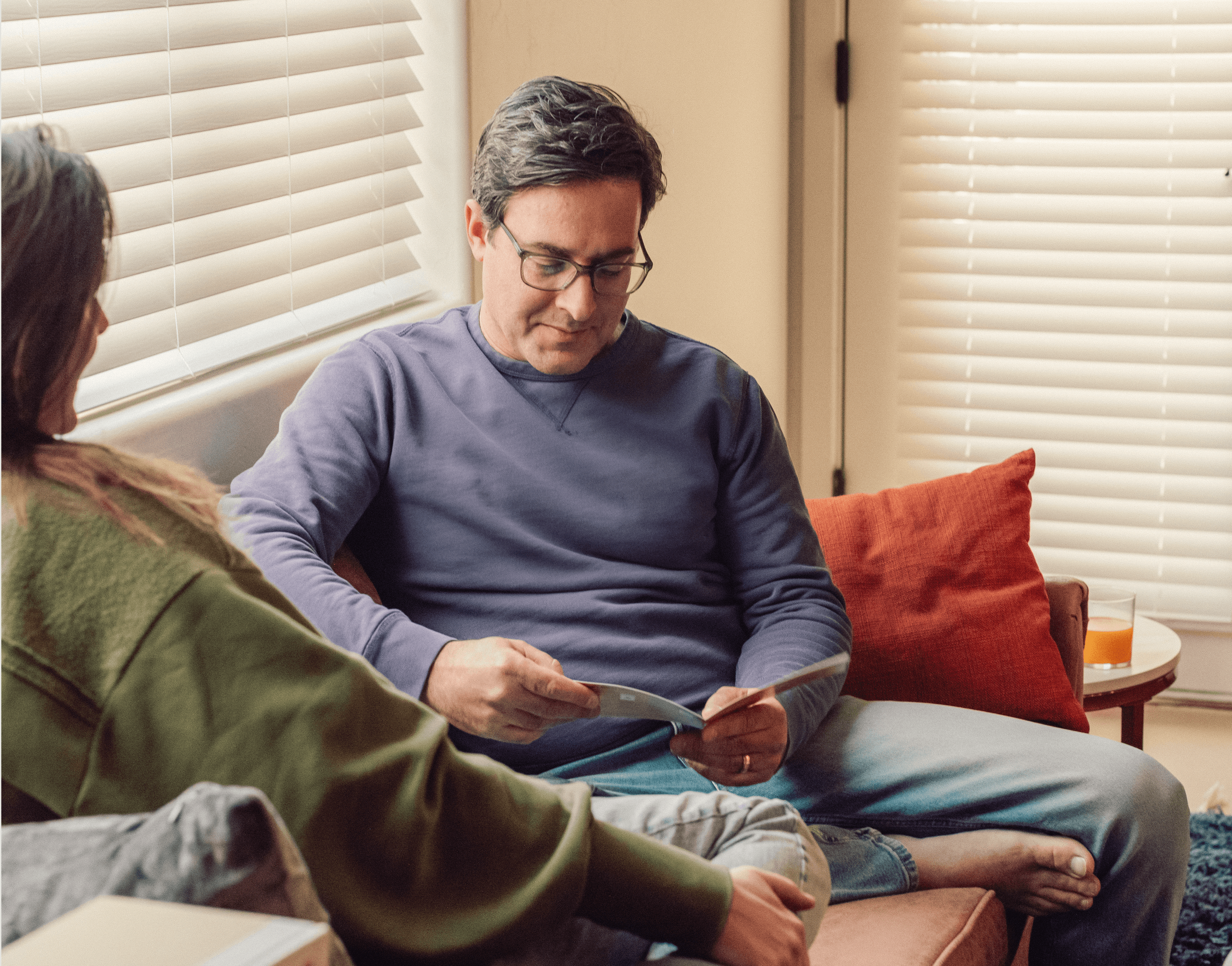 A man reads the instructions for his Fellow Vasectomy Test kit on the couch.