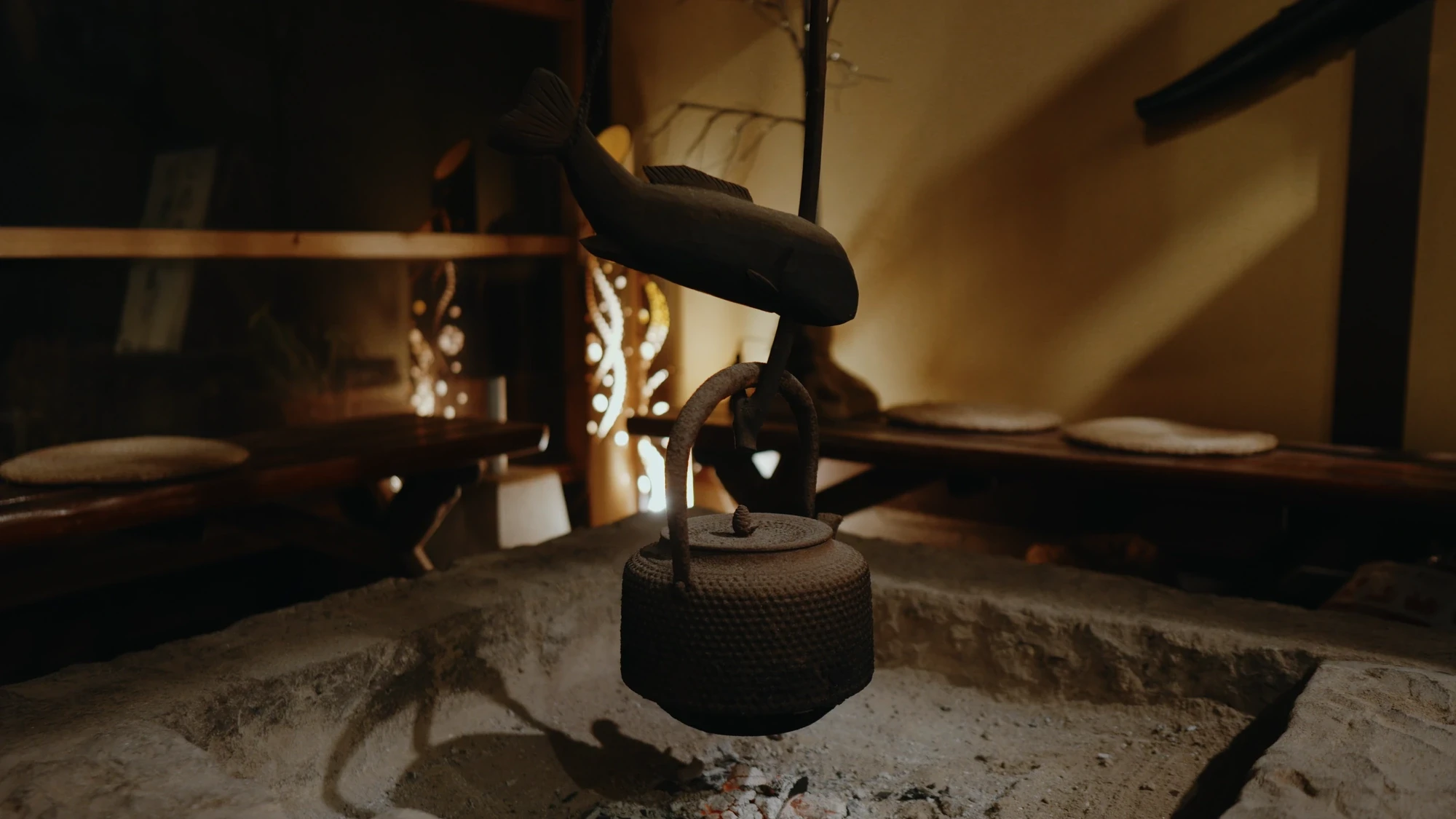 An irori hearth at a Kurokawa Onsen inn with an iron kettle hung over the sunken firepit