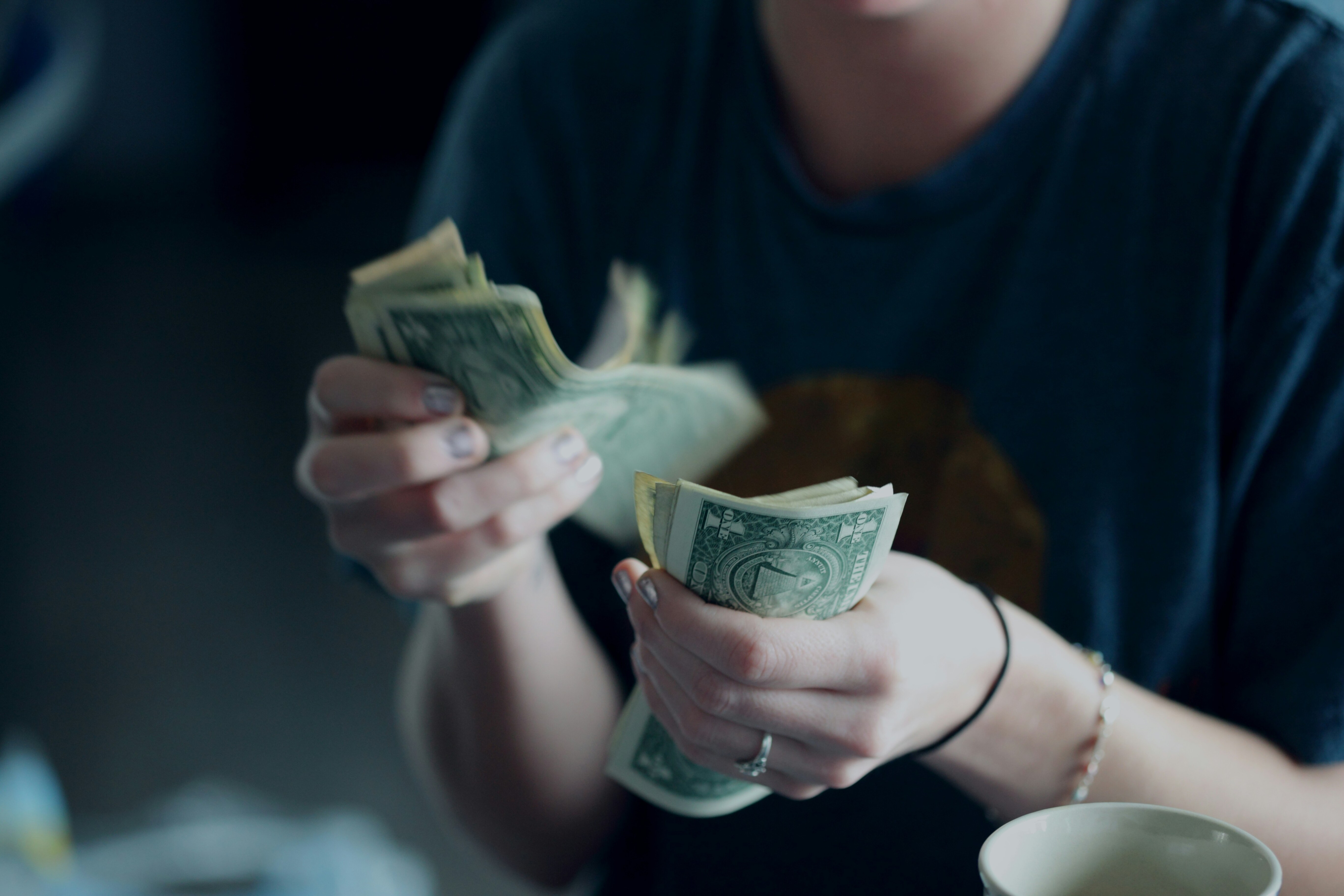 Young person's hands counting dollars