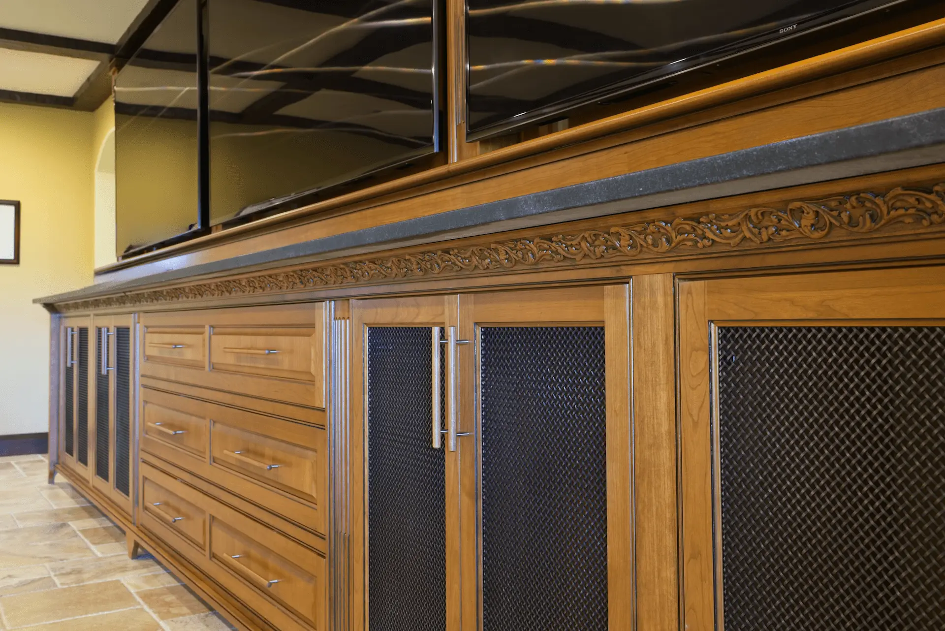 Close up shot of the entertainment room, displaying custom cabinetry and the multi-TV wall setup, for the ultimate entertainment experience in the San Juan Capistrano project. Photo by Todd Huge.