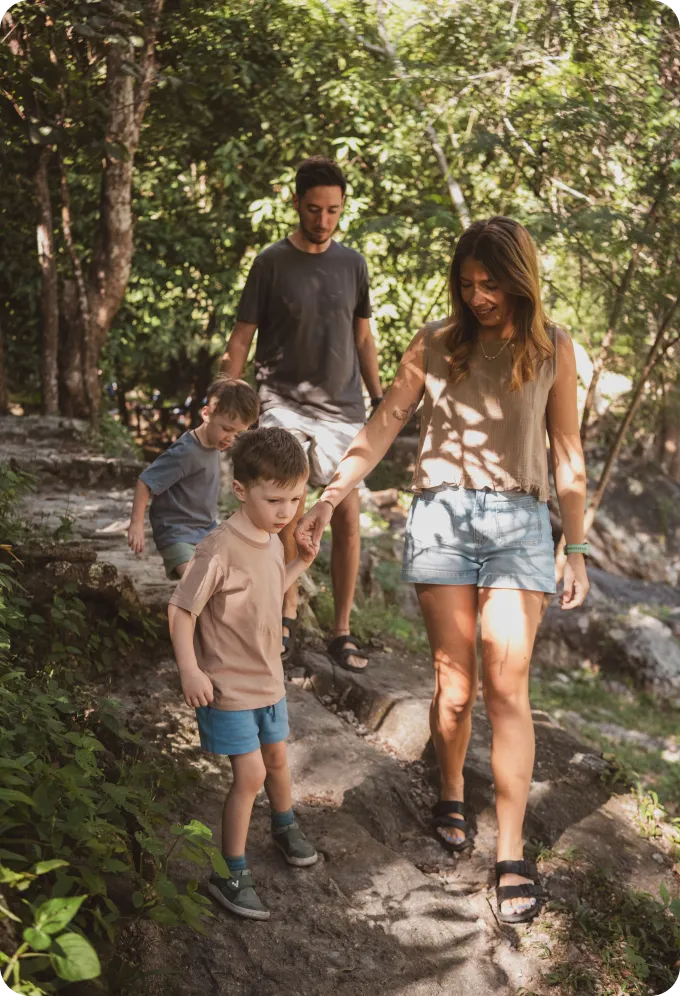 Emily and Phil walking through the woods with their children