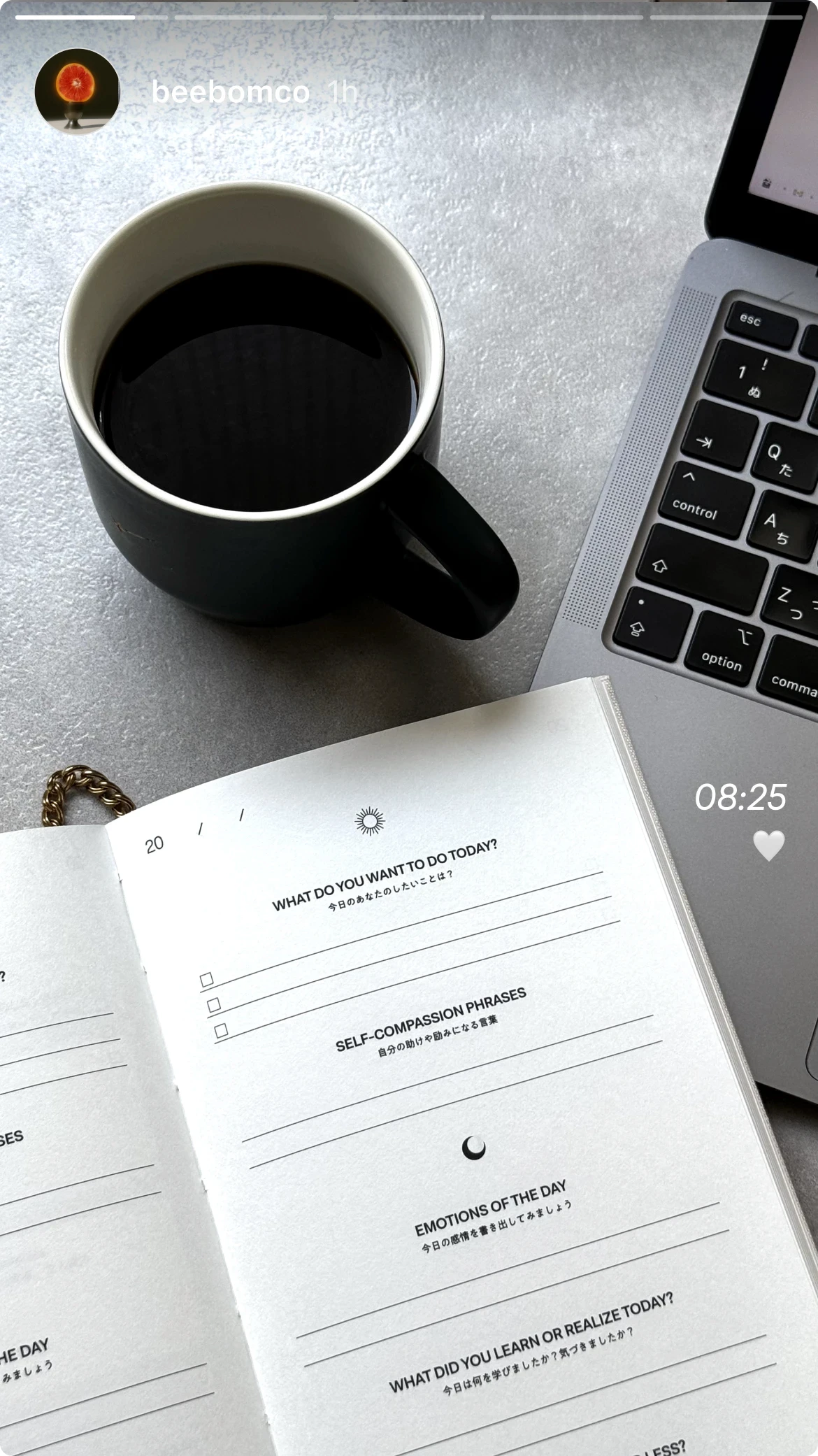 BETTER JOURNEY journal page with daily prompts next to a coffee mug and laptop, illustrating its integration into daily work and reflection routines