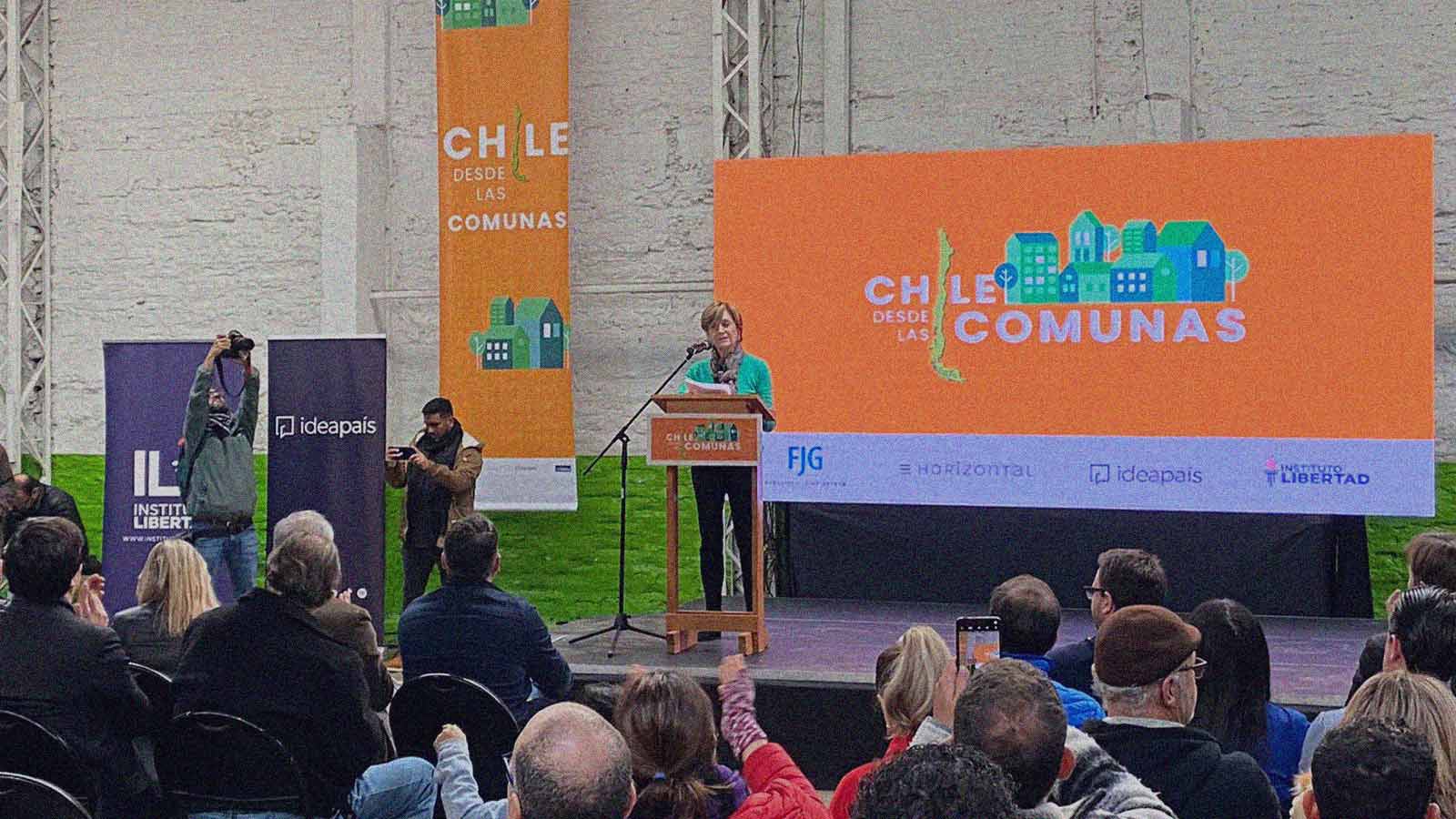 Foto de la excandidata presidencial Evelyn Matthei en un escenario presentando "Chile desde las comunas" ante los asistentes.