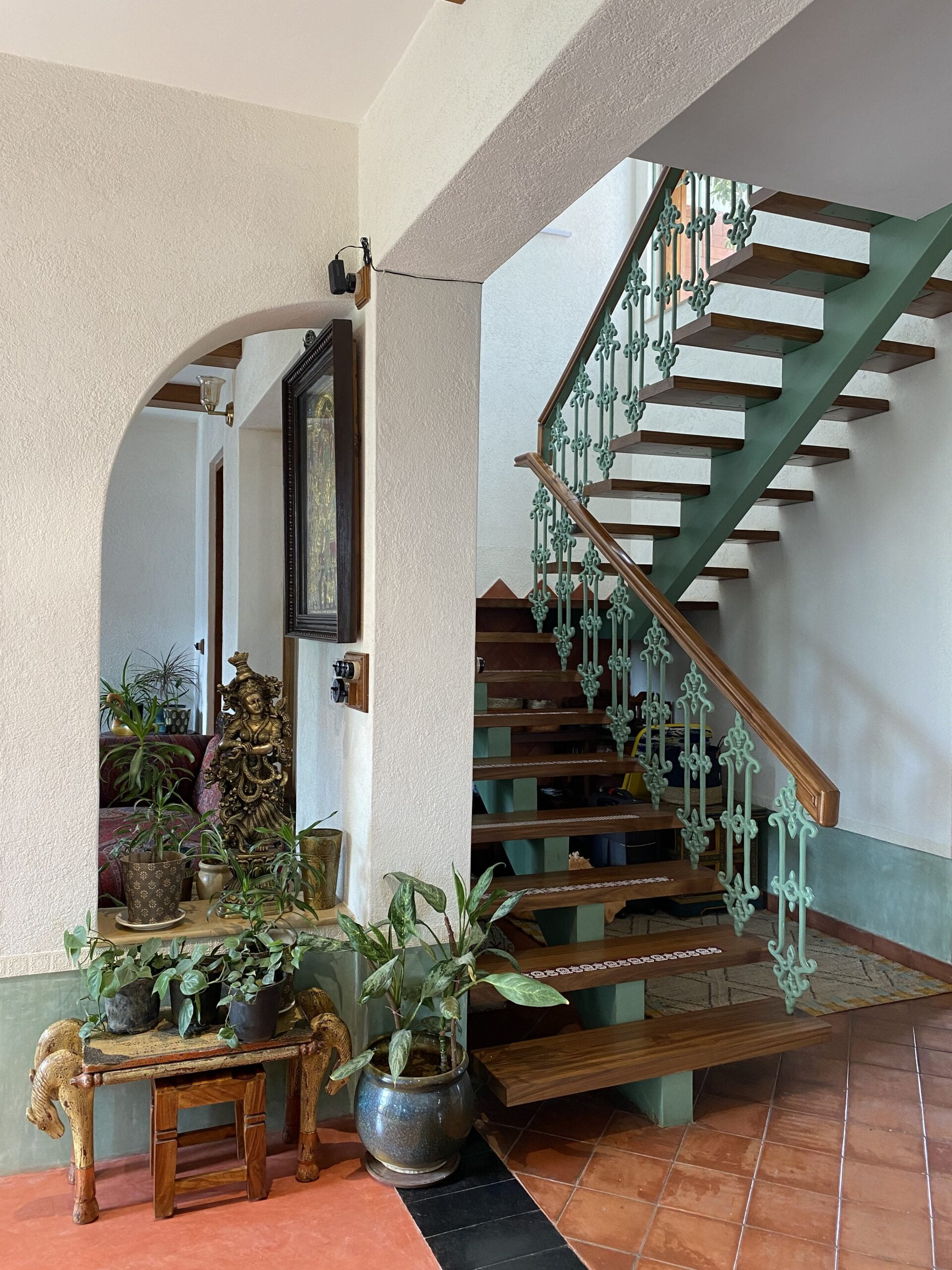 Heritage details: Traditional terracotta flooring and brass accents complement the ornate metal balustrade, grounding the space in a warm, cultural aesthetic.