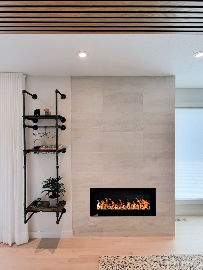 Image of Modern electric fireplace with industrial shelving unit and decor in a luxurious home design by KHD Homes.