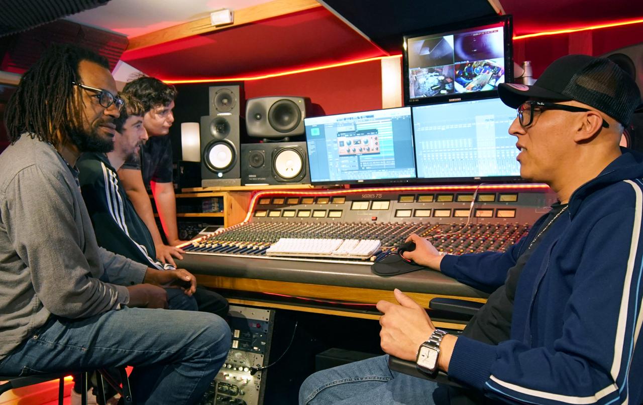 Notre studio d’enregistrement partenaire à Montpellier : échanges autour d’une console de mixage, avec enceintes de monitoring et écrans de production musicale.