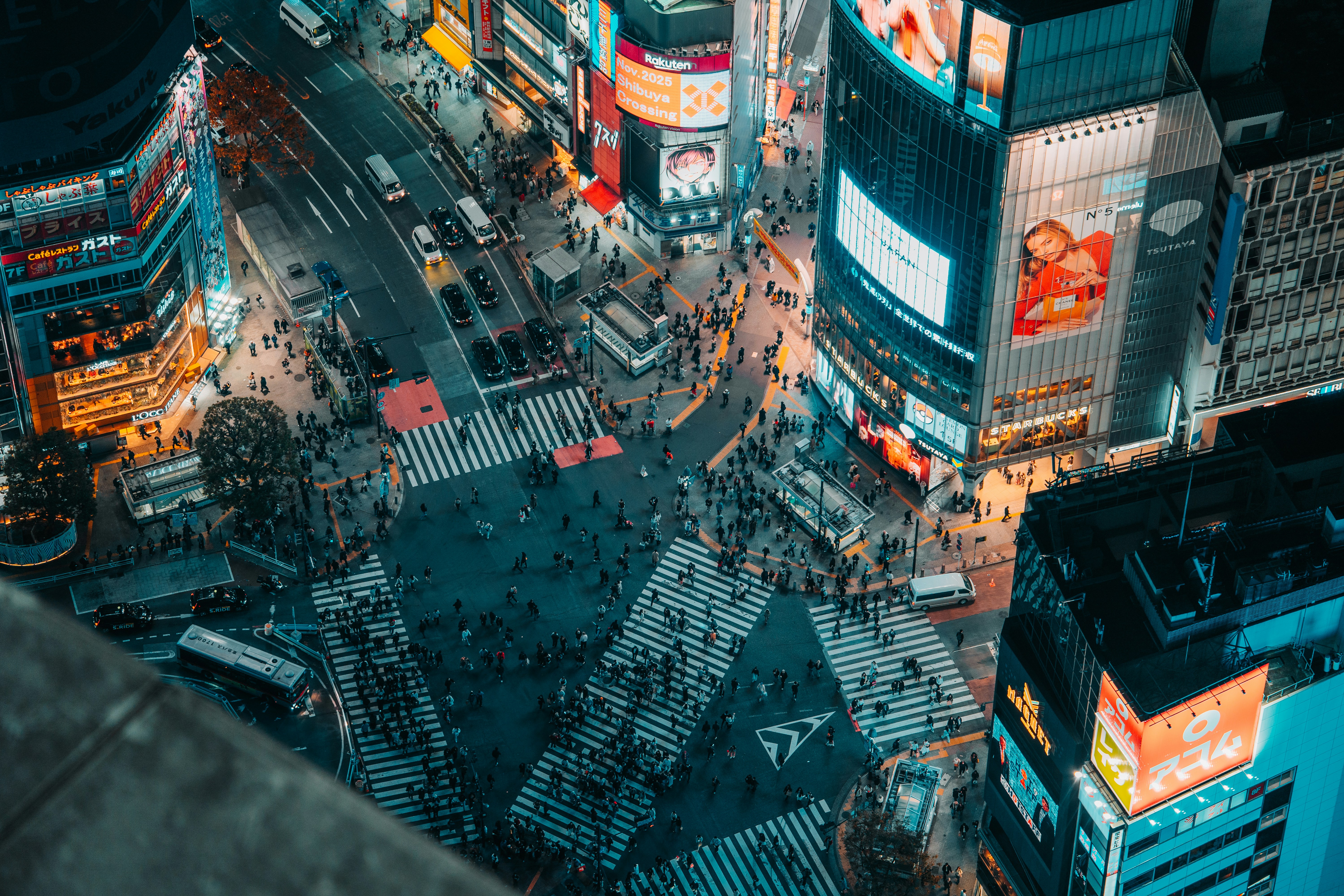 Busy nighttime cityscape with a large pedestrian crossing.