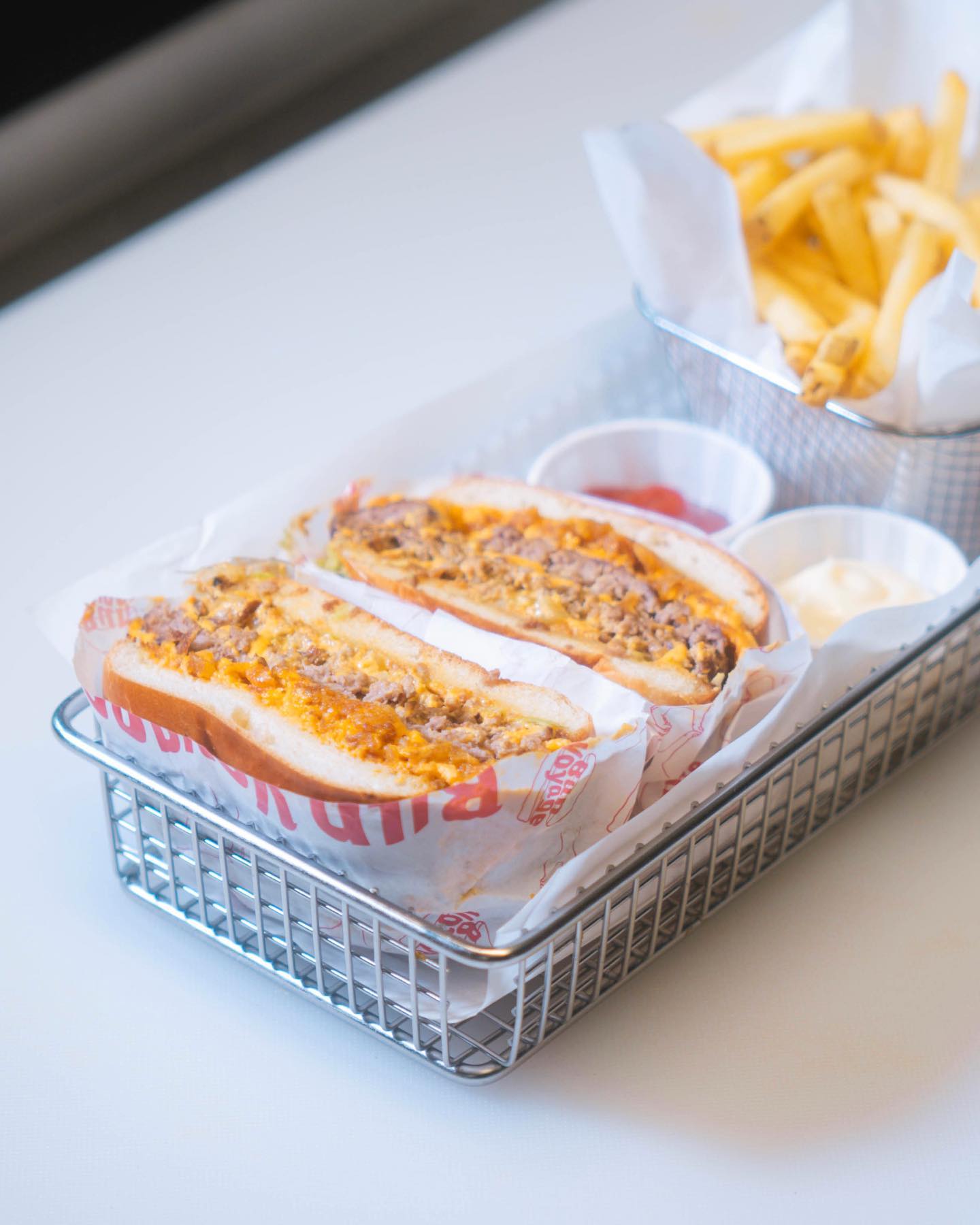 Basket of sandwiches and fries on a table.