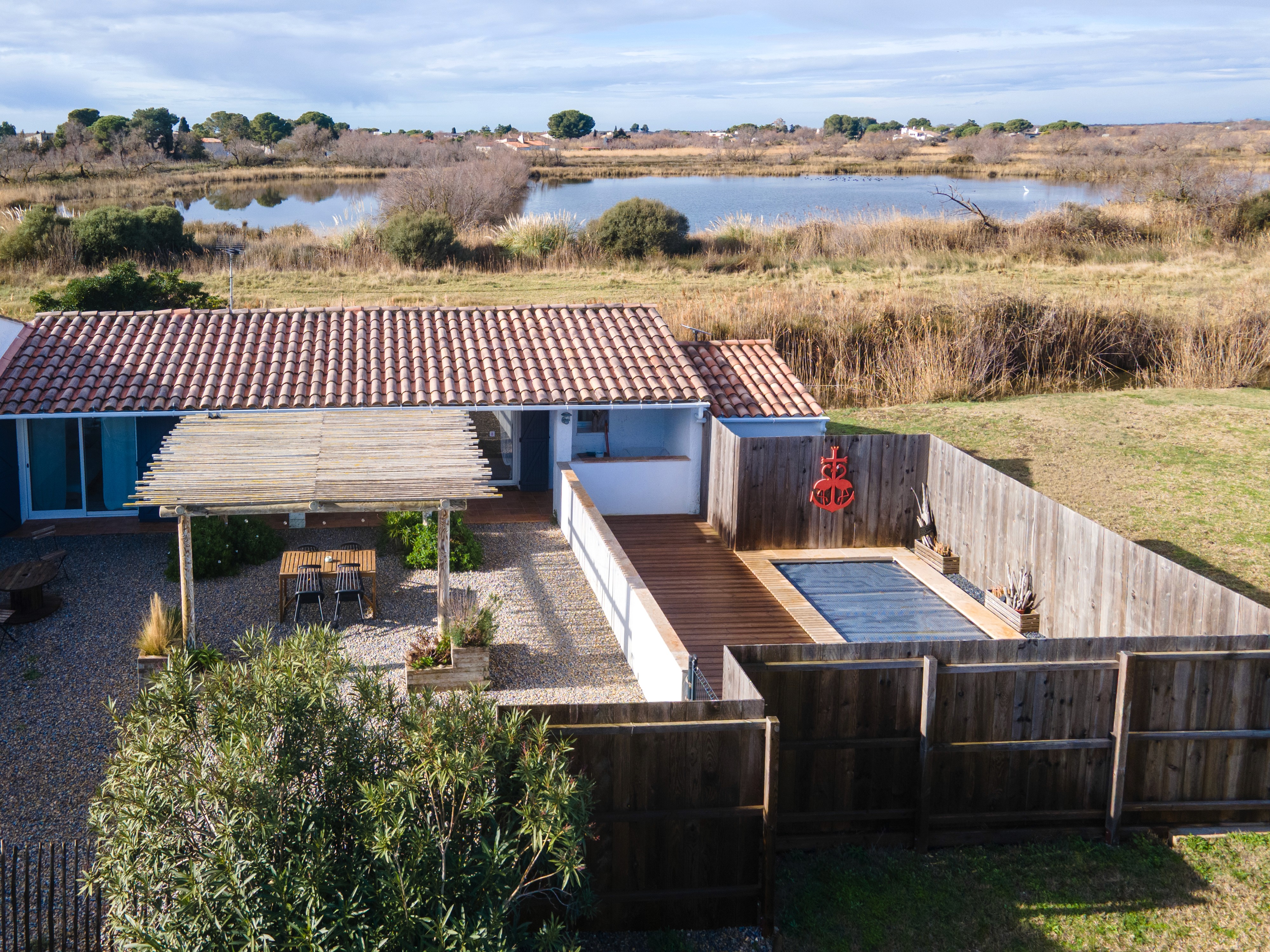 Décoration salon scandinave et bohème avec canapé gris, table basse en bois et cannage, et plantes vertes.