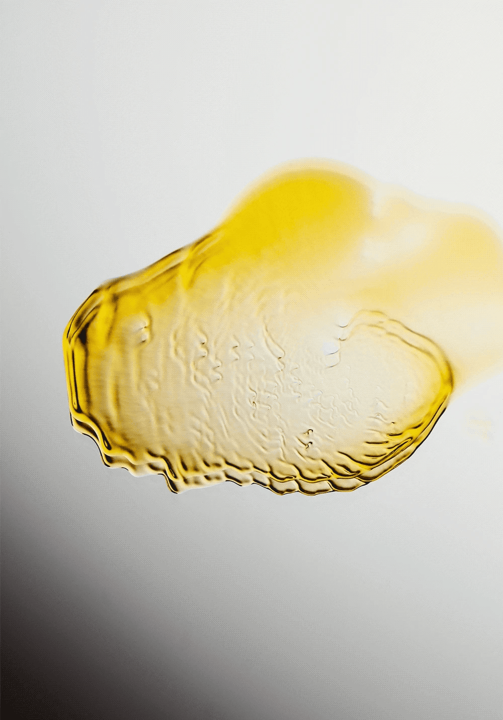 A textured smear of yellow paint on a light background, creating a dynamic, abstract visual effect.