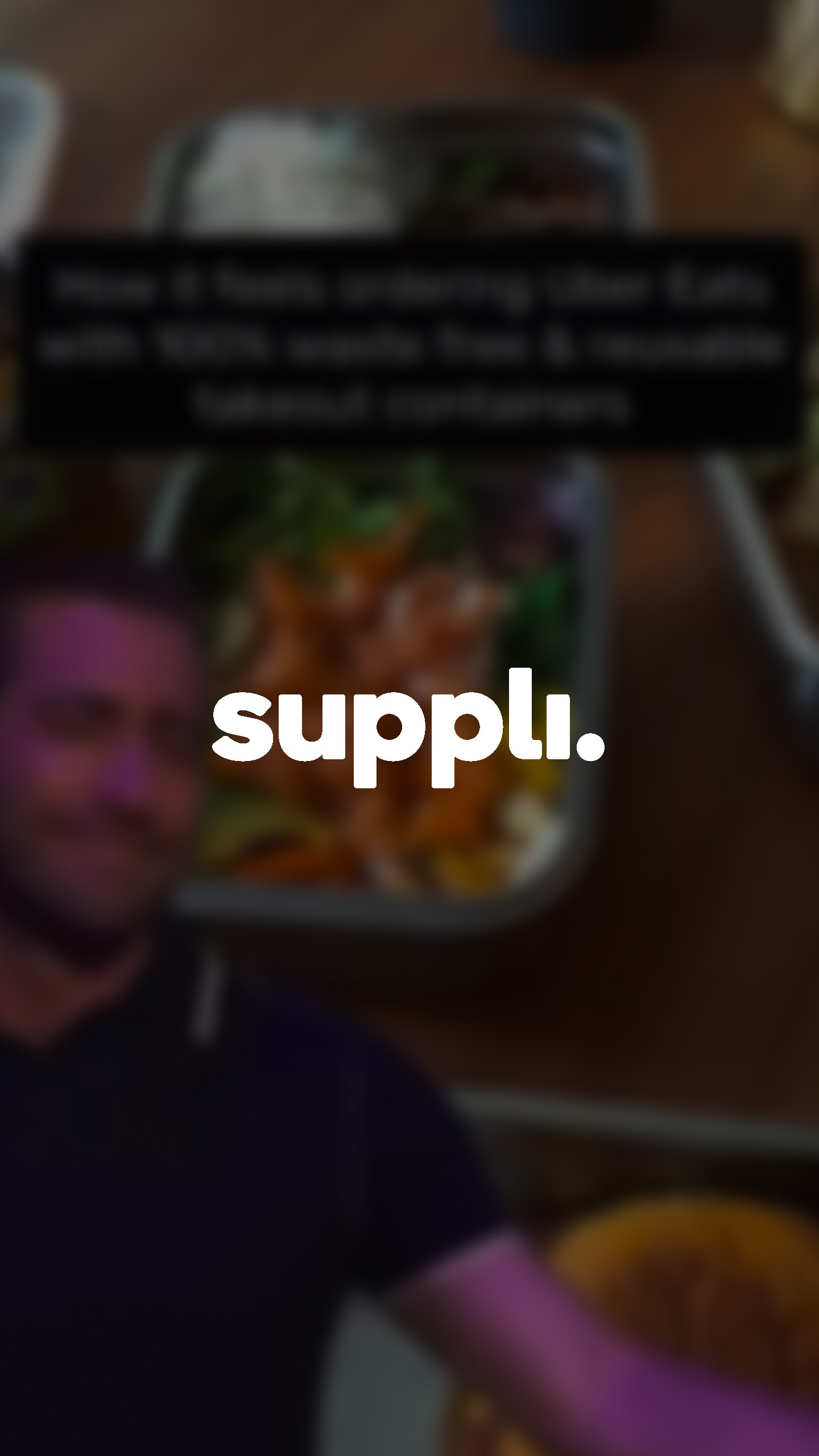 man holding black smartphone with flat screen monitor in front