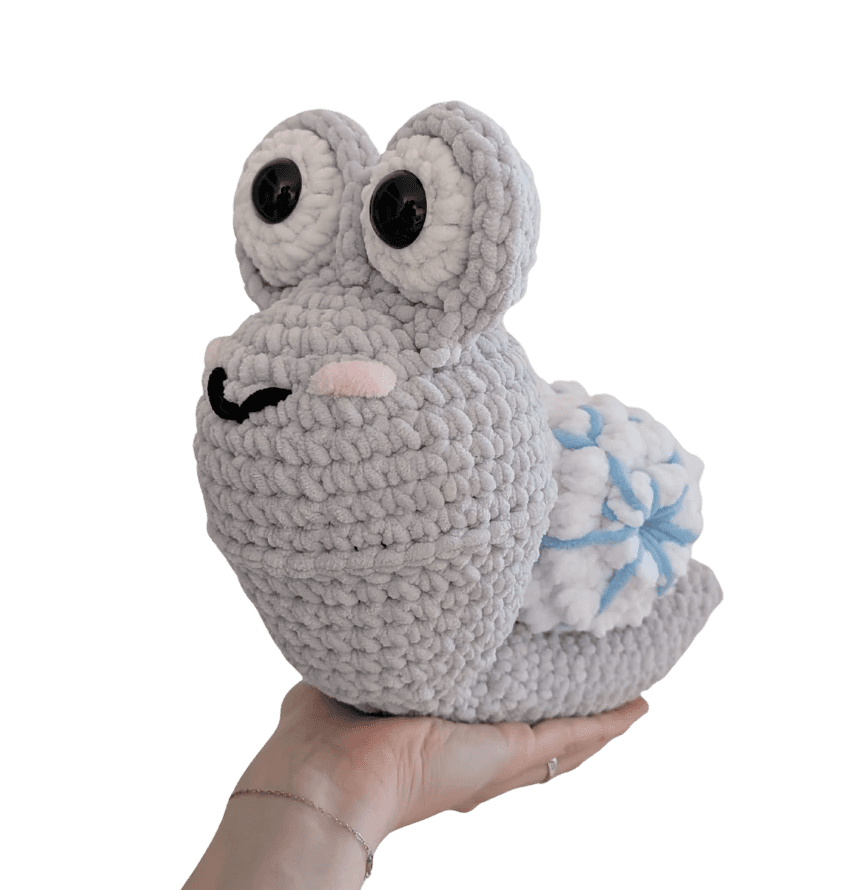 A cute, handcrafted plush acorn toy with brown yarn spikes and large, friendly eyes sits facing forward on a white background.