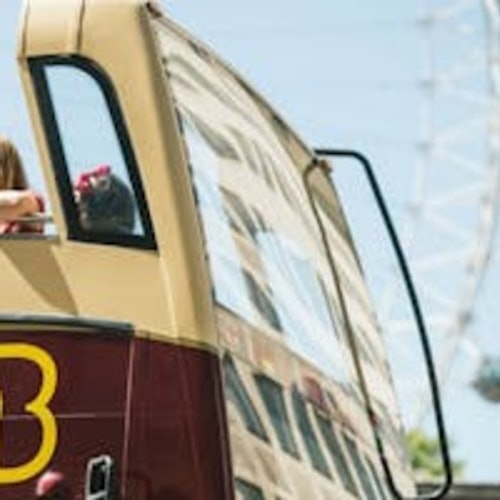 Una capsula panoramica in vetro sul London Eye con diverse persone al suo interno che osservano il panorama urbano sottostante.