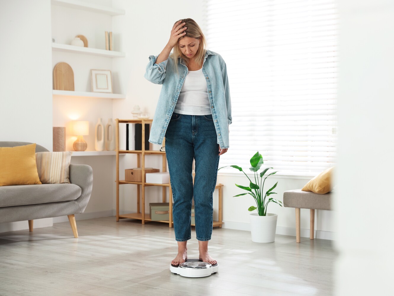 woman standing on a scale feeling frustrated from regaining weight after stopping her prescribed medicine for weight loss
