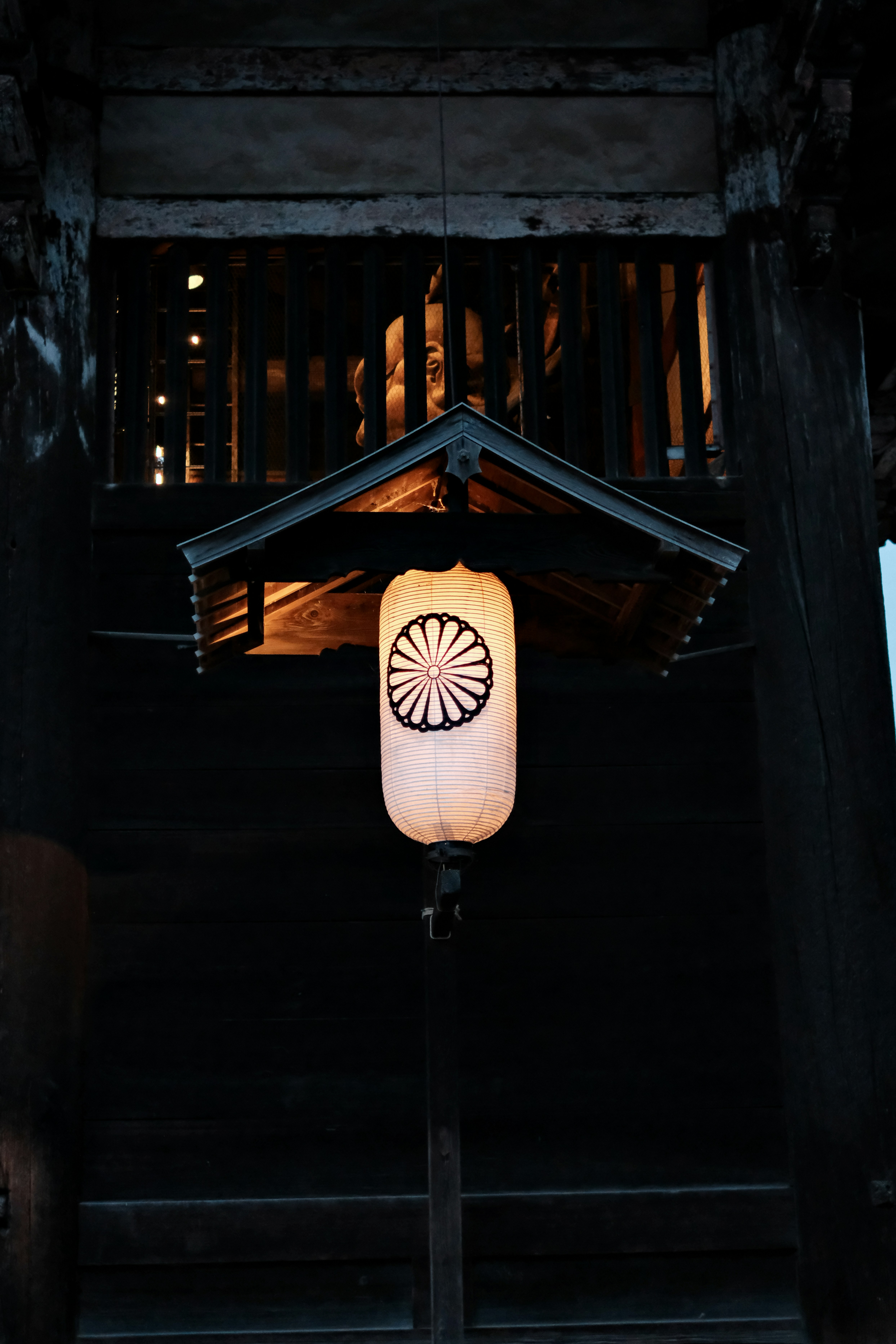 Japanese lantern hanging under a temple roof at night, illustrating an article on East Asian aesthetics.