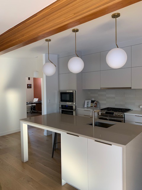 Image of Modern kitchen design with island, pendant lights, and stainless steel appliances by KHD Homes builders.