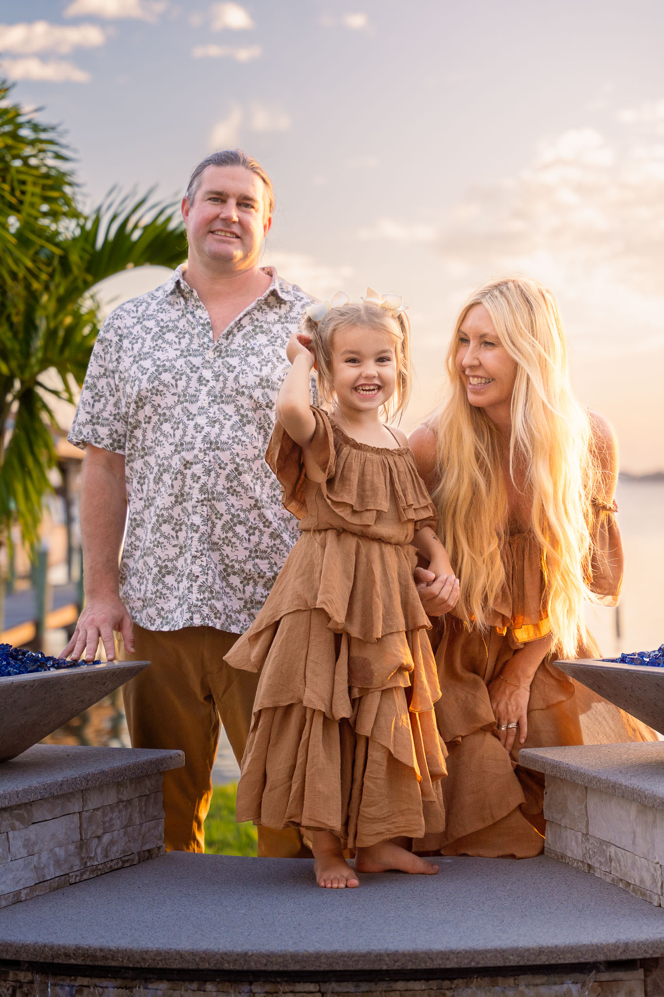  a man standing in front of a woman while a woman smiles at her daughter