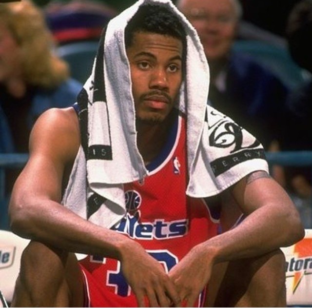 A green butterfly rests on a flower.