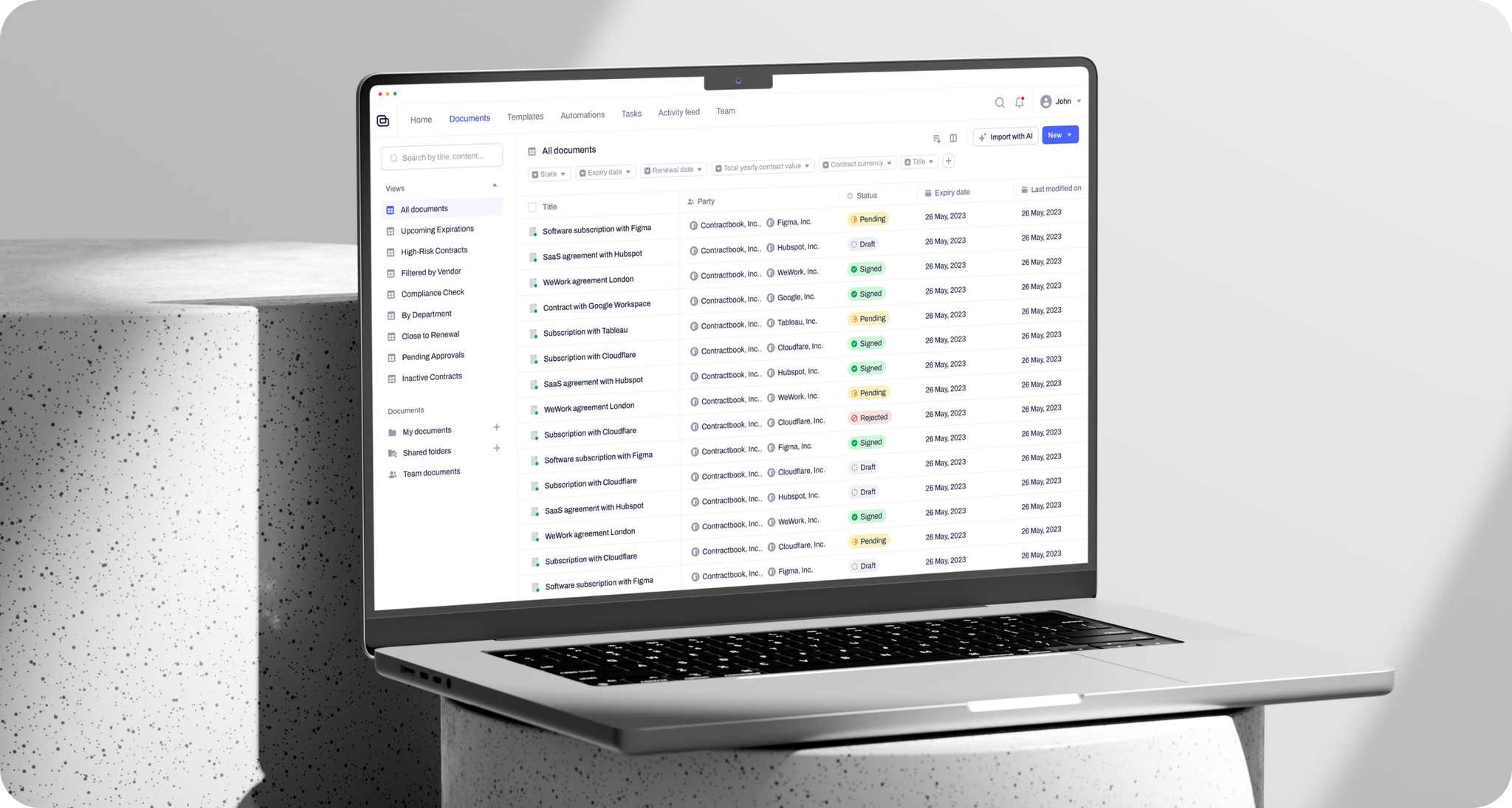 Laptop screen showing a contract management dashboard with document statuses.