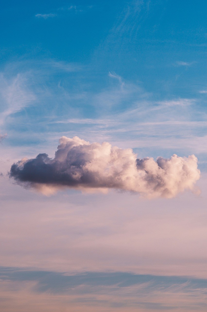 Große, weiche Wolke auf blau-rosa Hintergrund als beruhigendes visuelles Element für Angstpatienten.