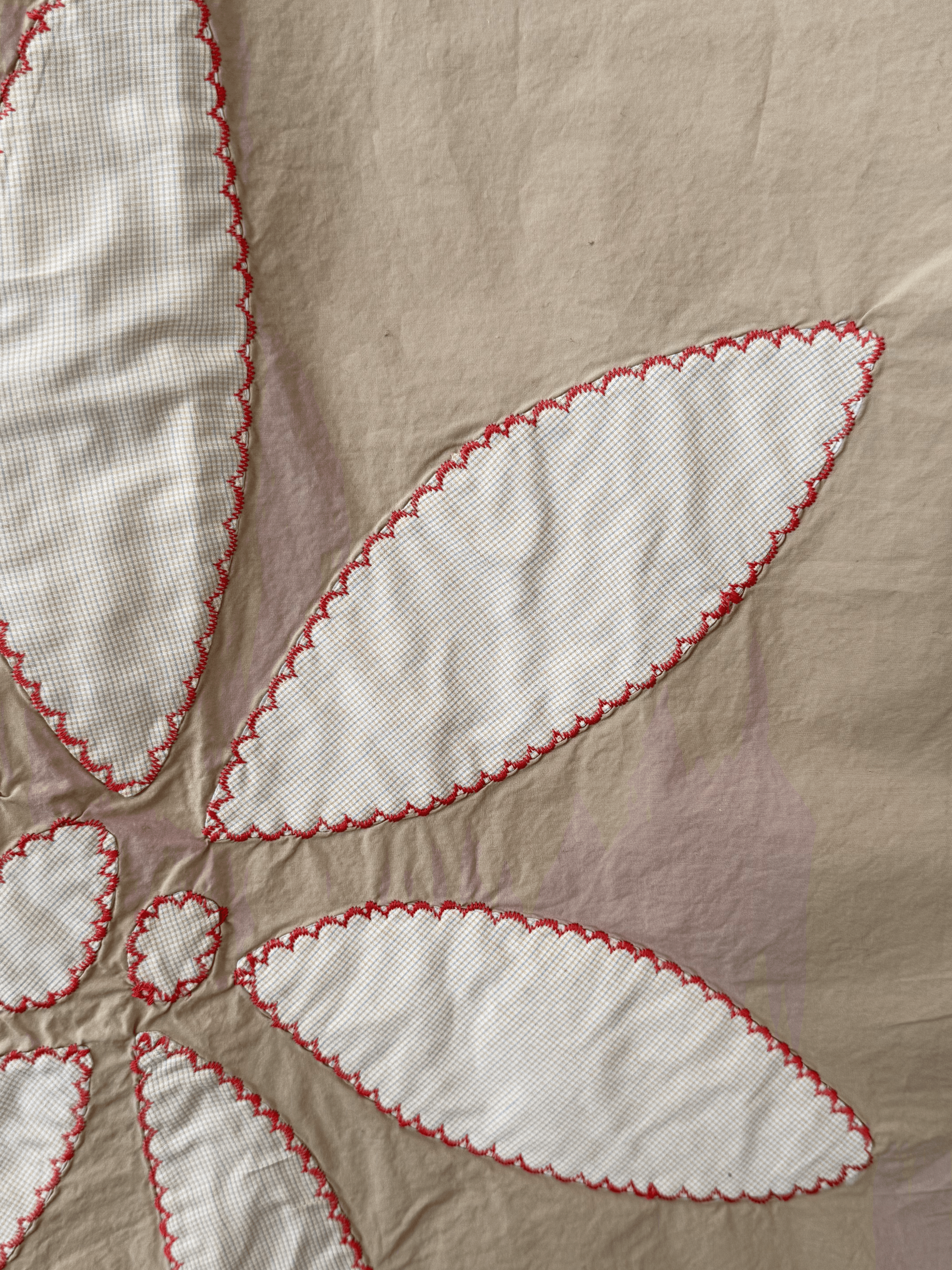 close-up of beige long skirt with some white flower petal patchwork