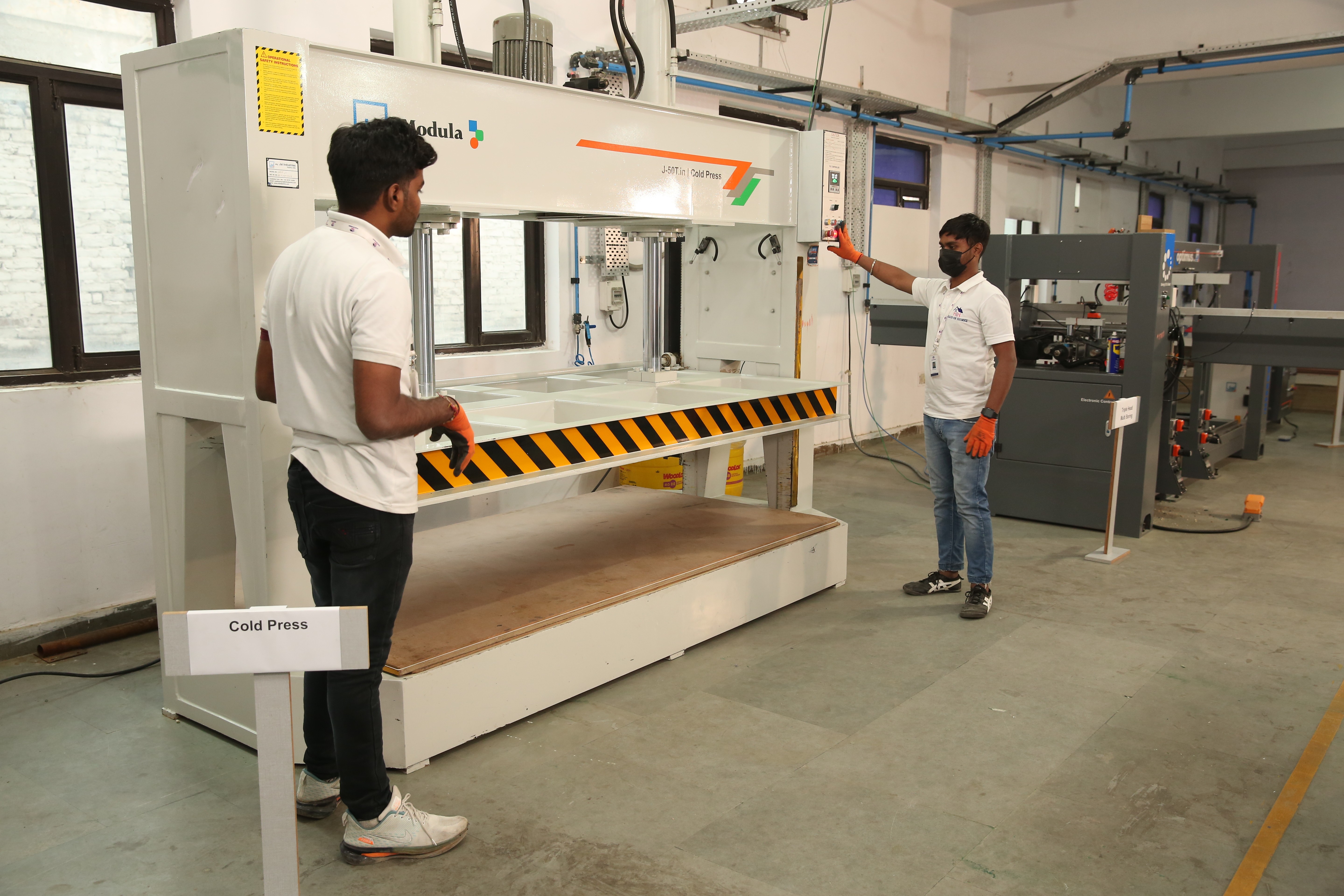 A technician operating the 50-ton cold press at the Haus of Homez factory in Noida