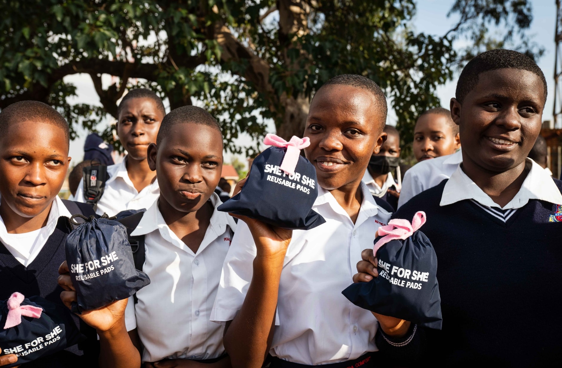 Group of girls holding SHE FOR SHE reusable menstrual pads.