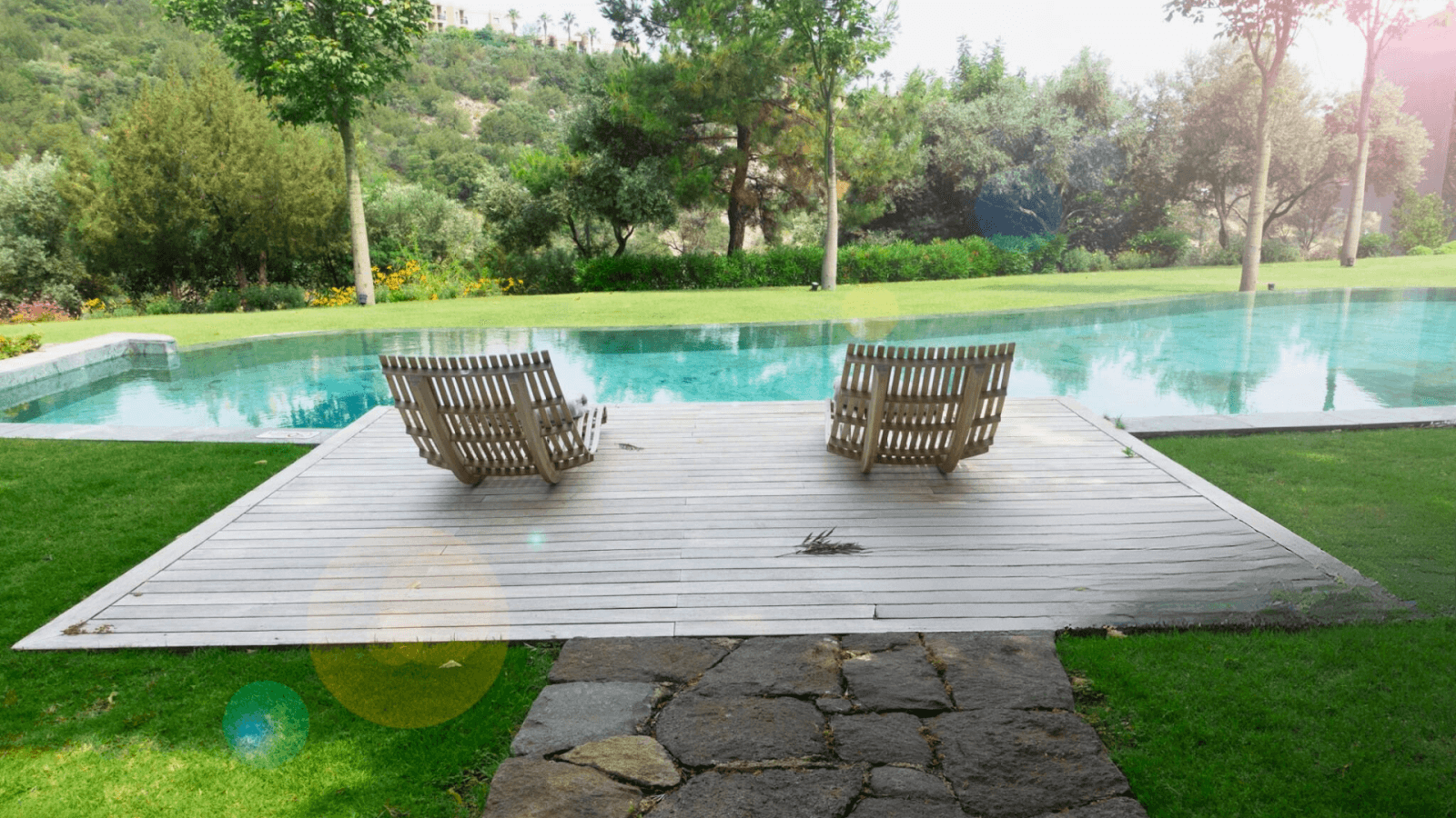 Rustic stone pool area with reclaimed wood decking, blending seamlessly with natural surroundings in Central Ohio.