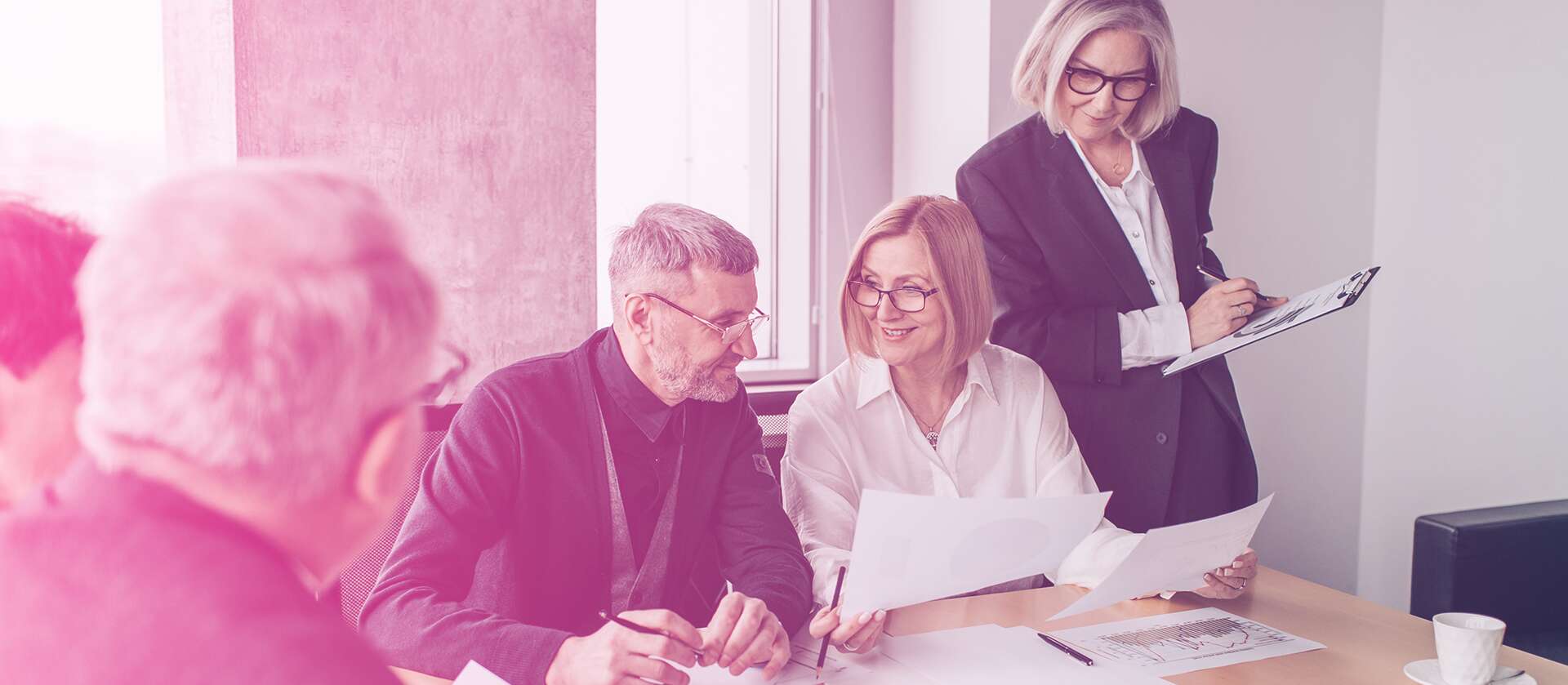 Three business professionals reviewing documents together in an office