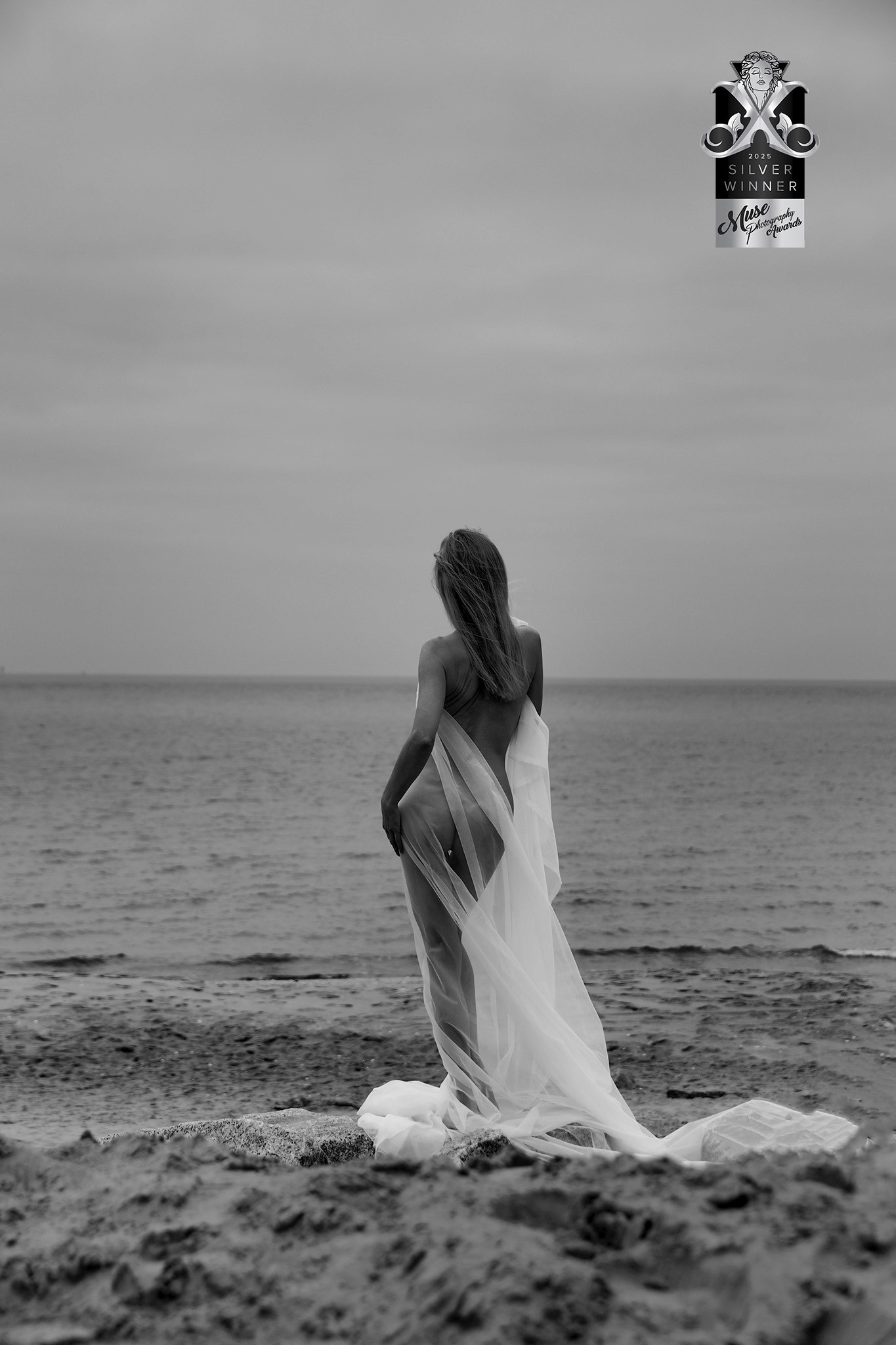 Agnieszka Czyzkowska fine art photography Warsaw woman in tulle dress standing by the sea back view black and white Solitude