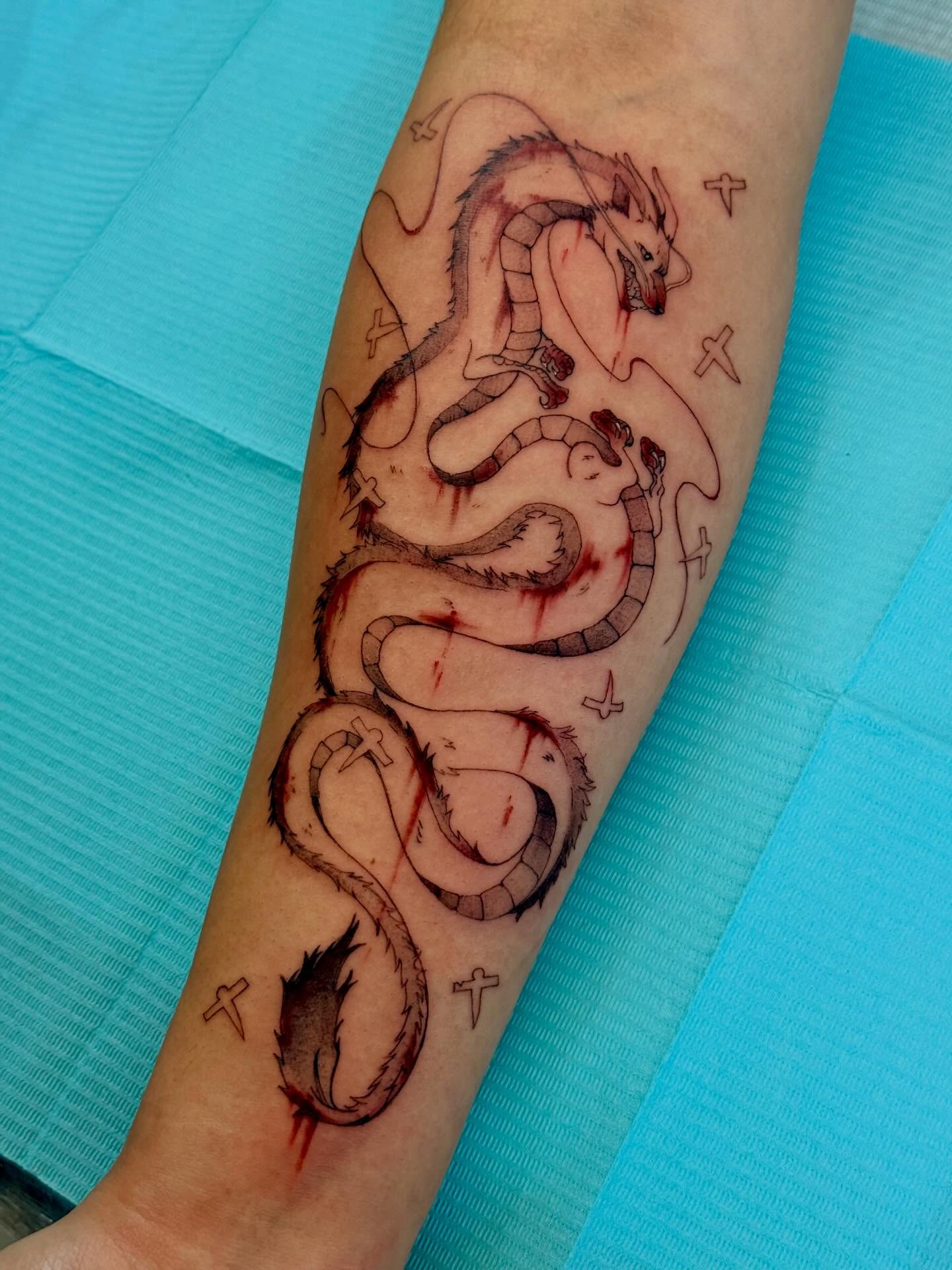 A forearm tattoo of Nezuko Kamado from Demon Slayer, depicted in a stylized anime art style. She is holding a sword.